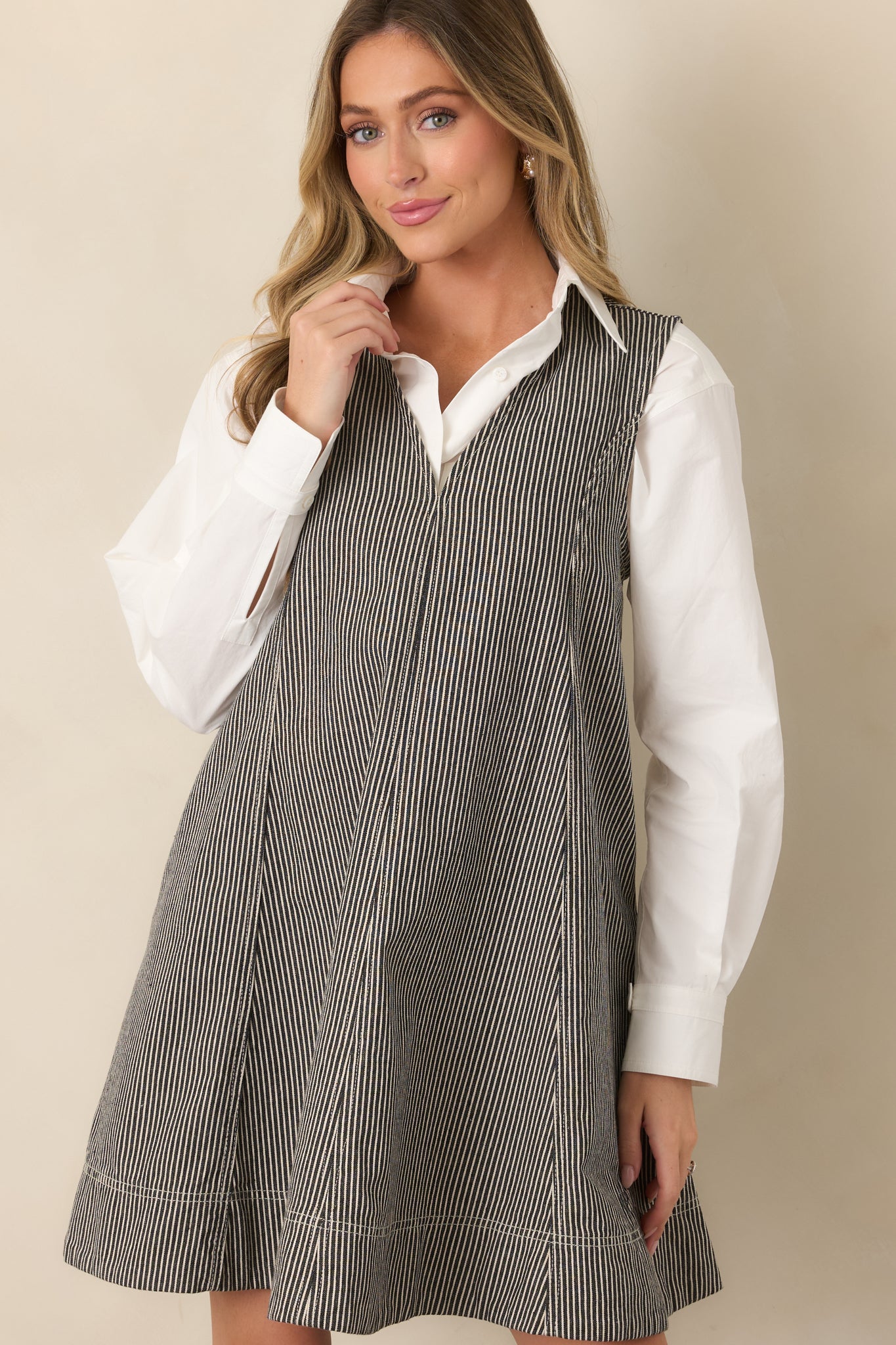 Striped anthracite grey mini dress featuring a deep V-neckline, sleeveless design, subtly structured seams, and a feminine flared silhouette.