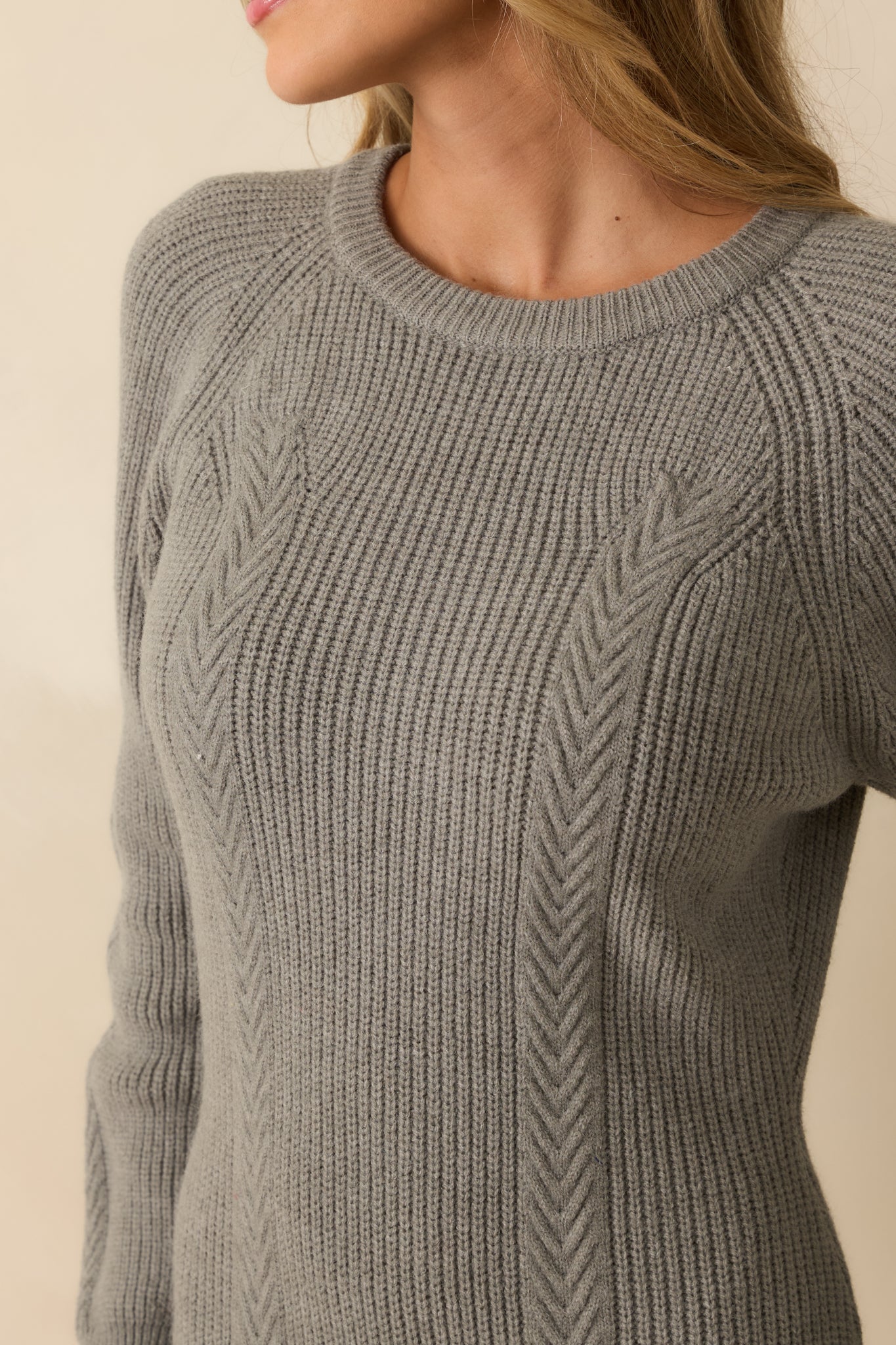 Close-up of ribbed crew neckline and knit texture on grey sweater dress.