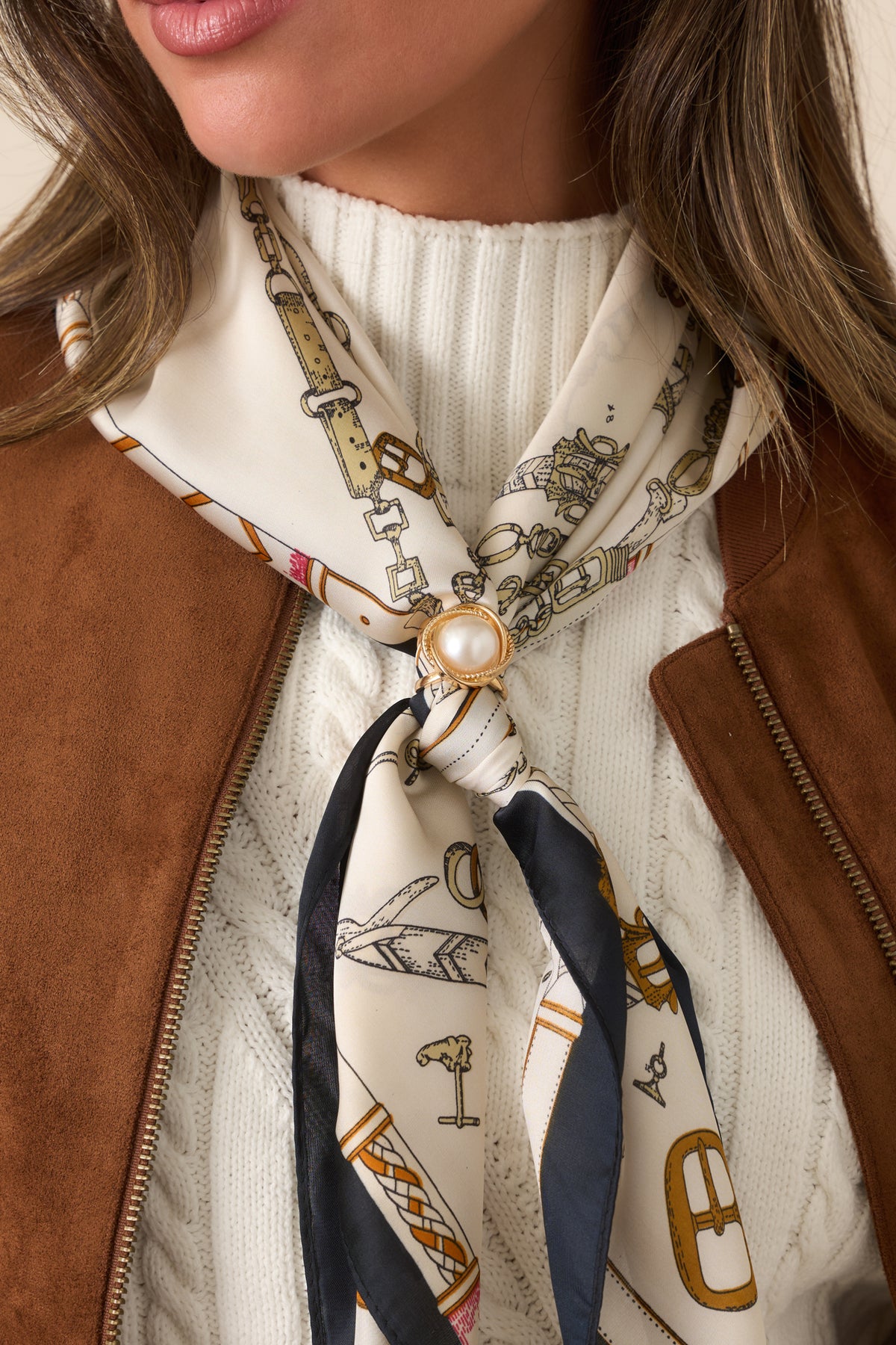 Close-up of the luminous pearl accent surrounded by a textured gold-tone border on the hair scarf.