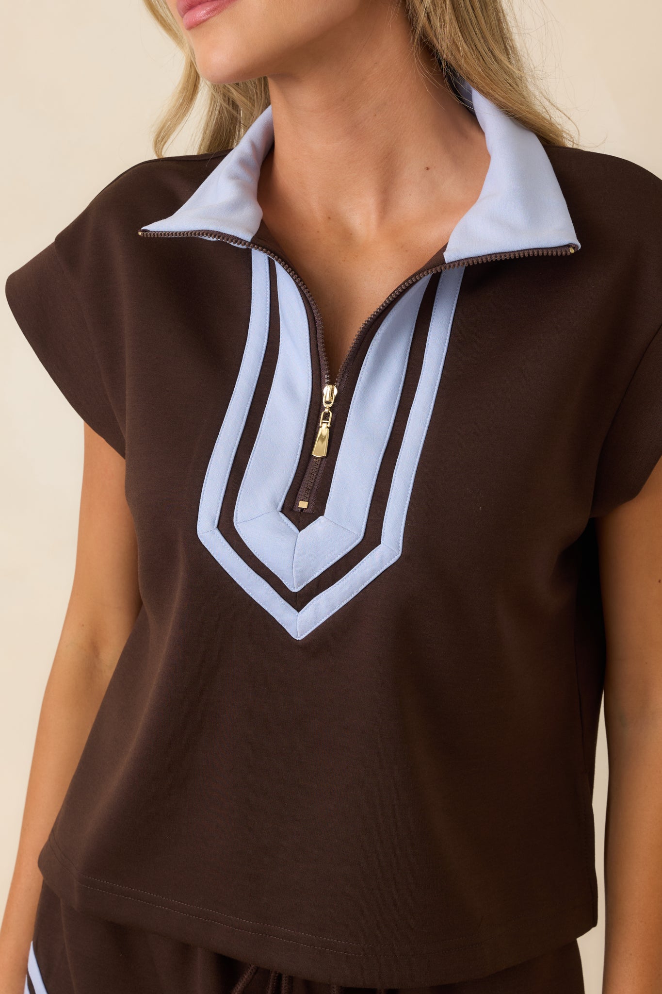 Half-zip top highlighting the collared neckline, contrast edging, and clean modern construction.