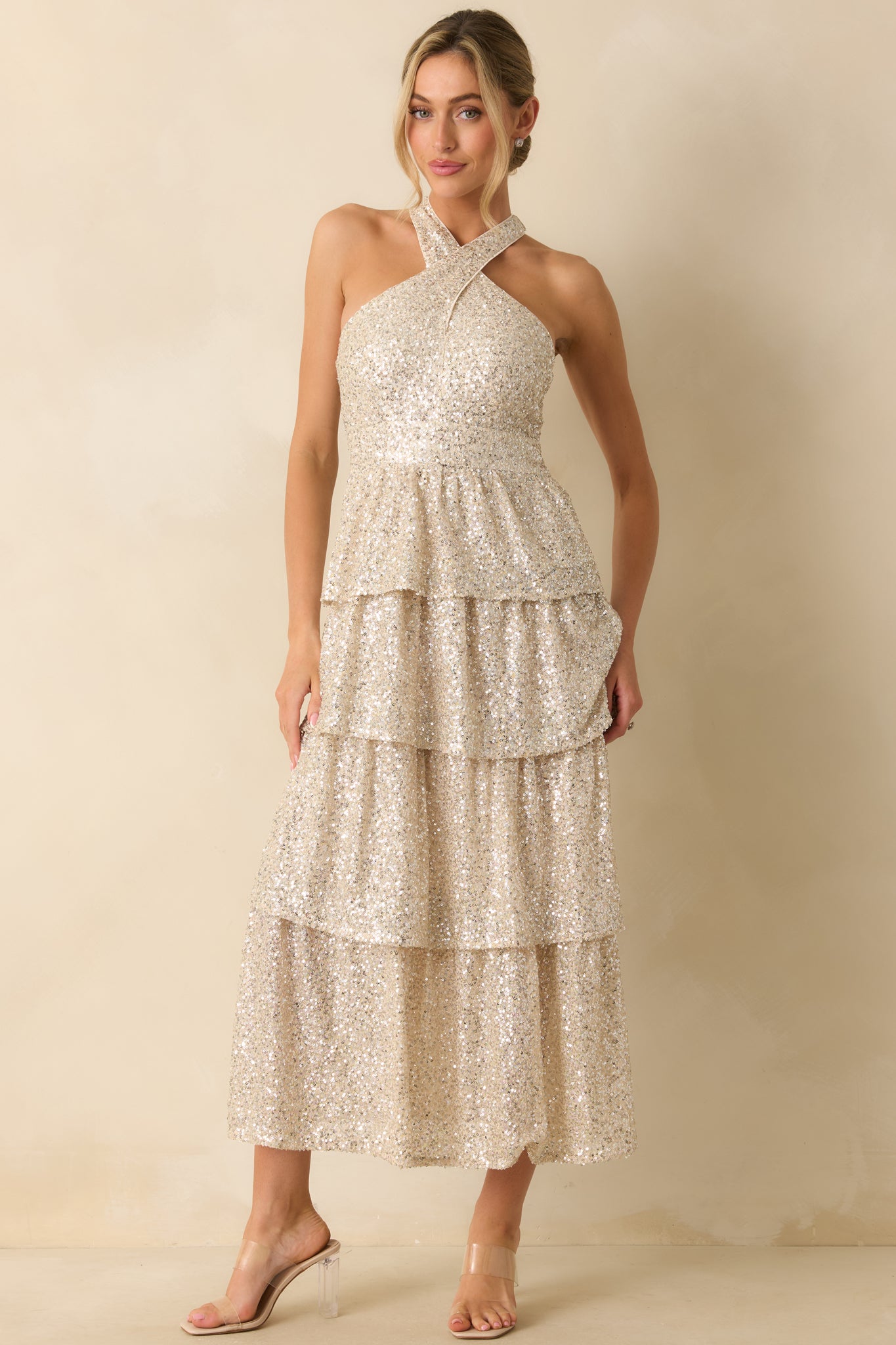 Halter-neck champagne sequin maxi dress with fully sequined bodice and cascading tiered skirt.