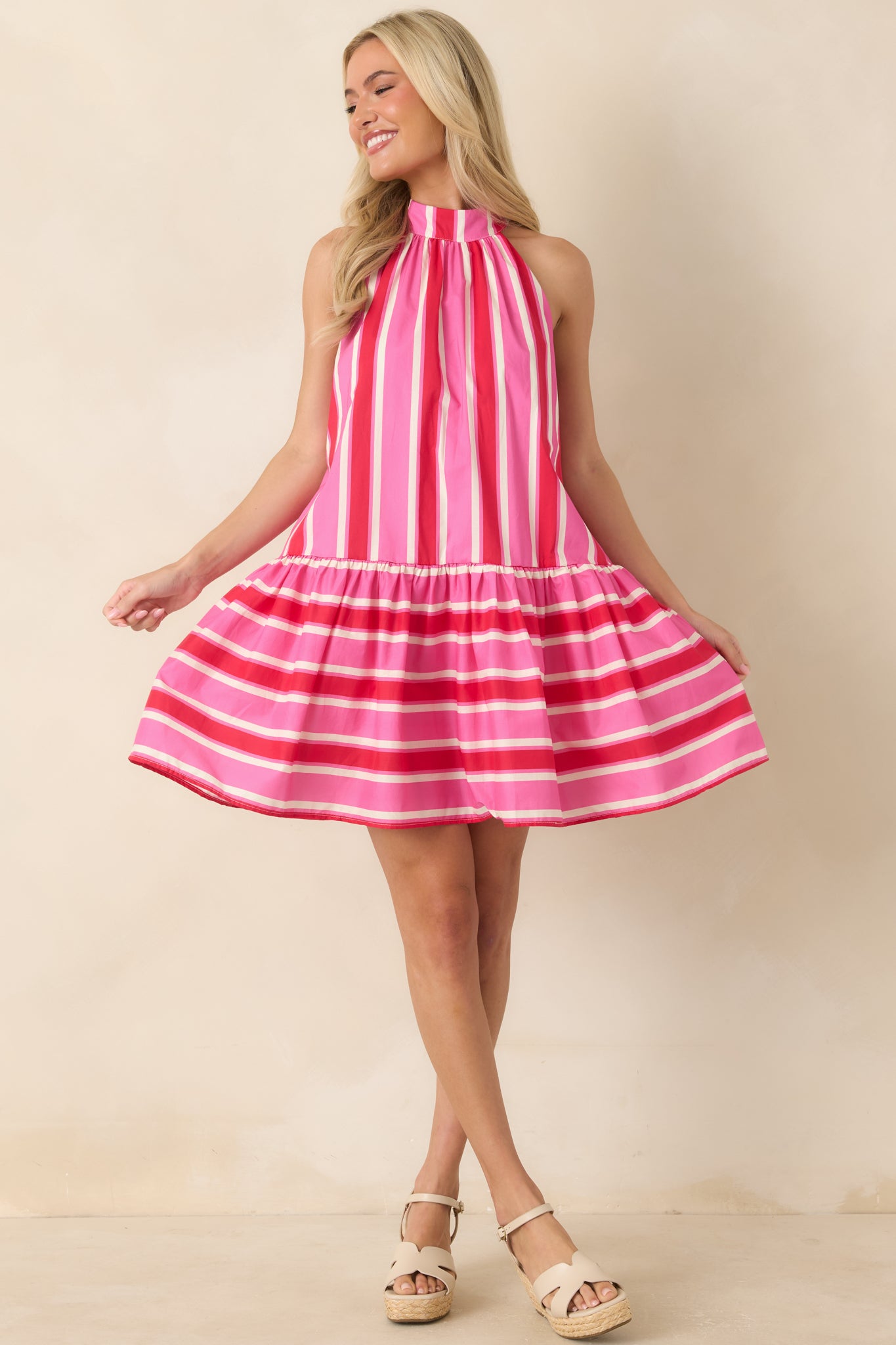 Mini dress featuring a halter neckline with tie closure, tiered gathered skirt, and breezy silhouette designed for warm-weather wear.
