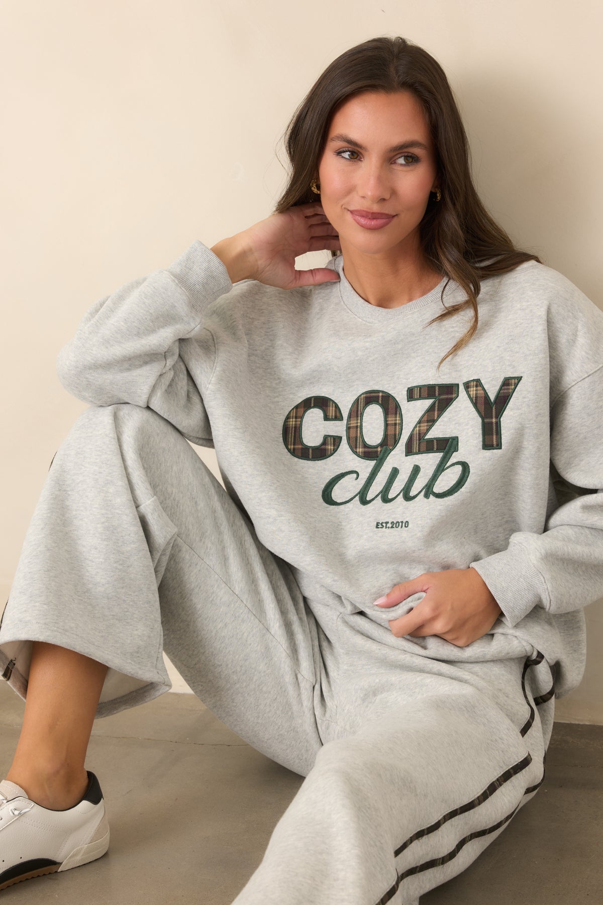 Heather grey sweatshirt showcasing the plaid lettering detail and soft-looking long-sleeve design.
