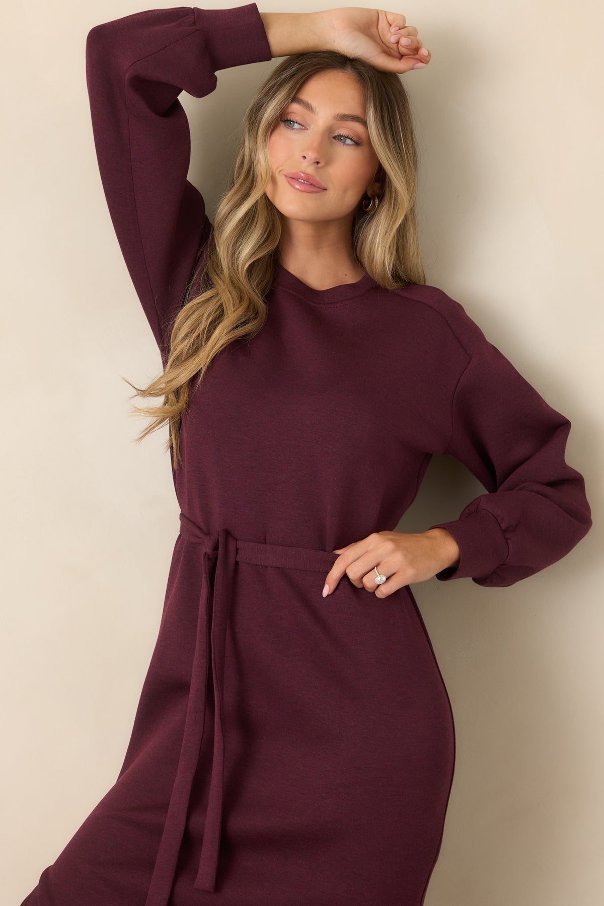 Close-up of the heathered burgundy fabric, crew neckline, and sporty banded trim.