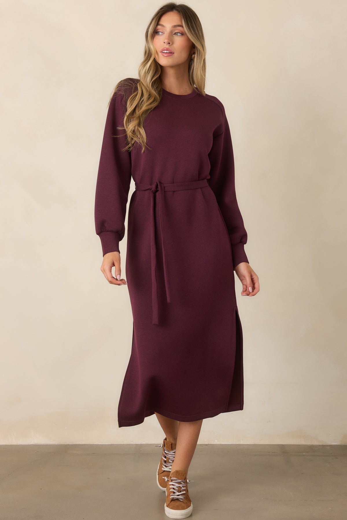 Heathered burgundy midi dress showcasing its relaxed shape, long sleeves, and straight skirt with side slits.
