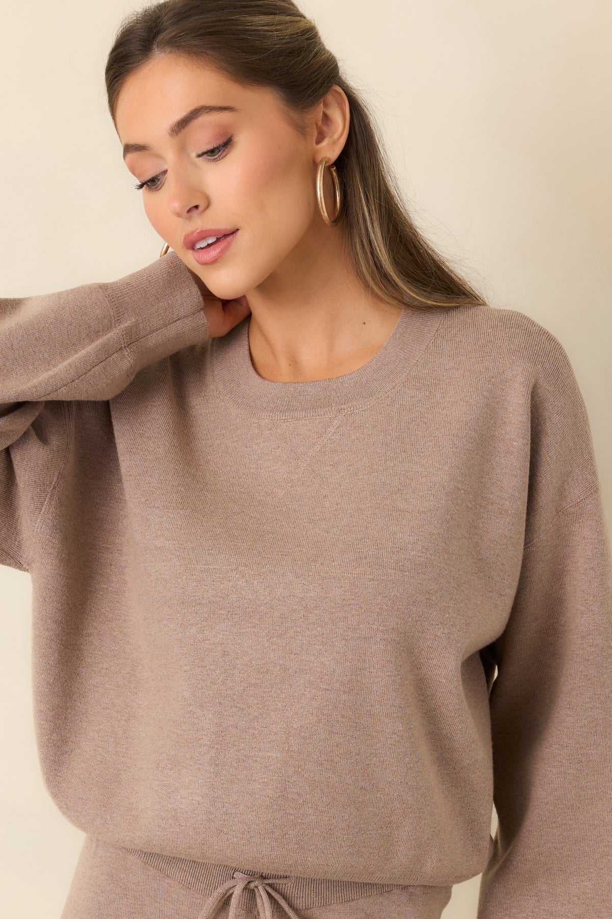 Heathered taupe pullover highlighting its ribbed crew neckline and soft sweater knit.