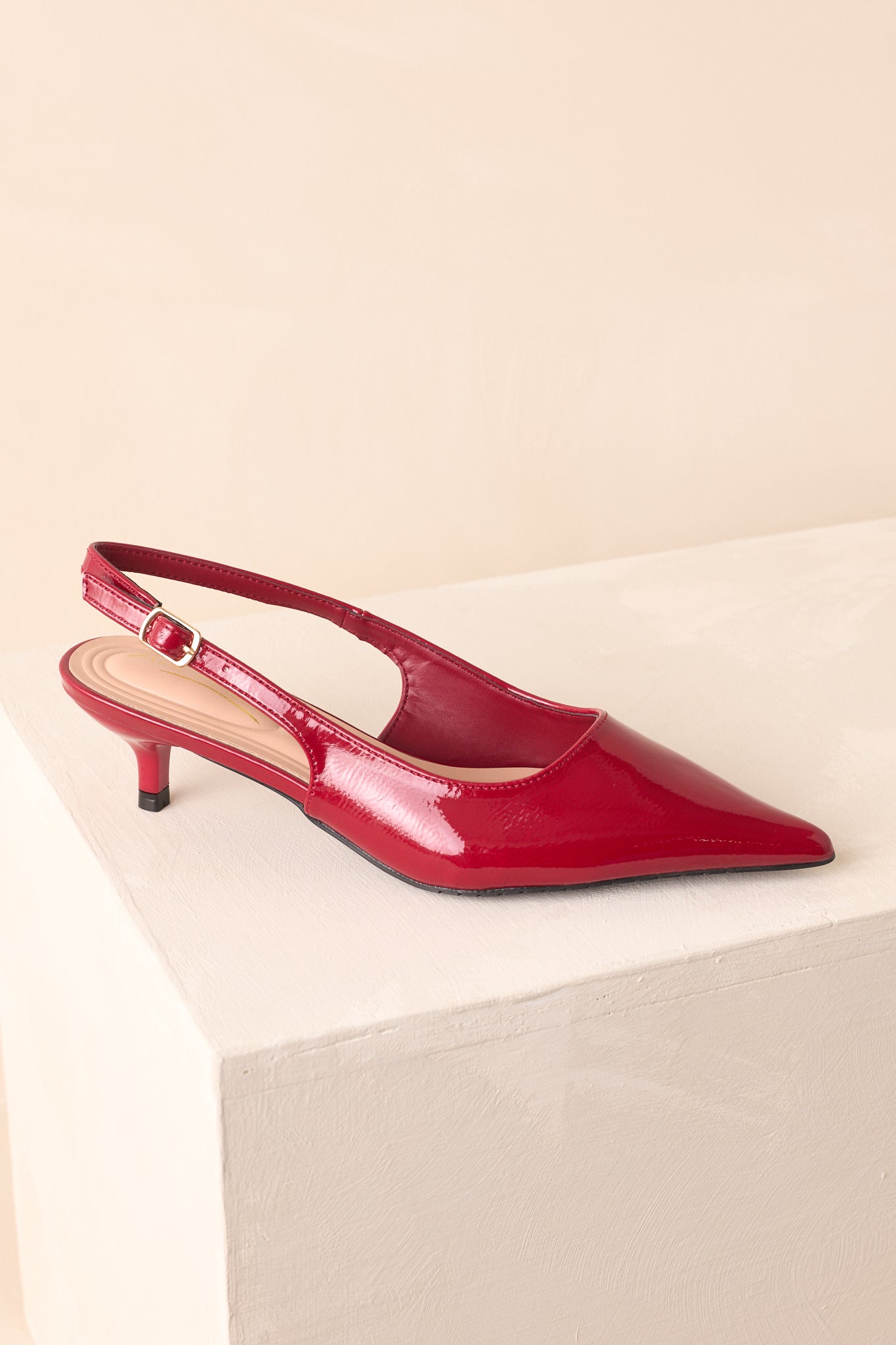 Side profile of the heels highlighting the sleek patent finish and kitten heel height.