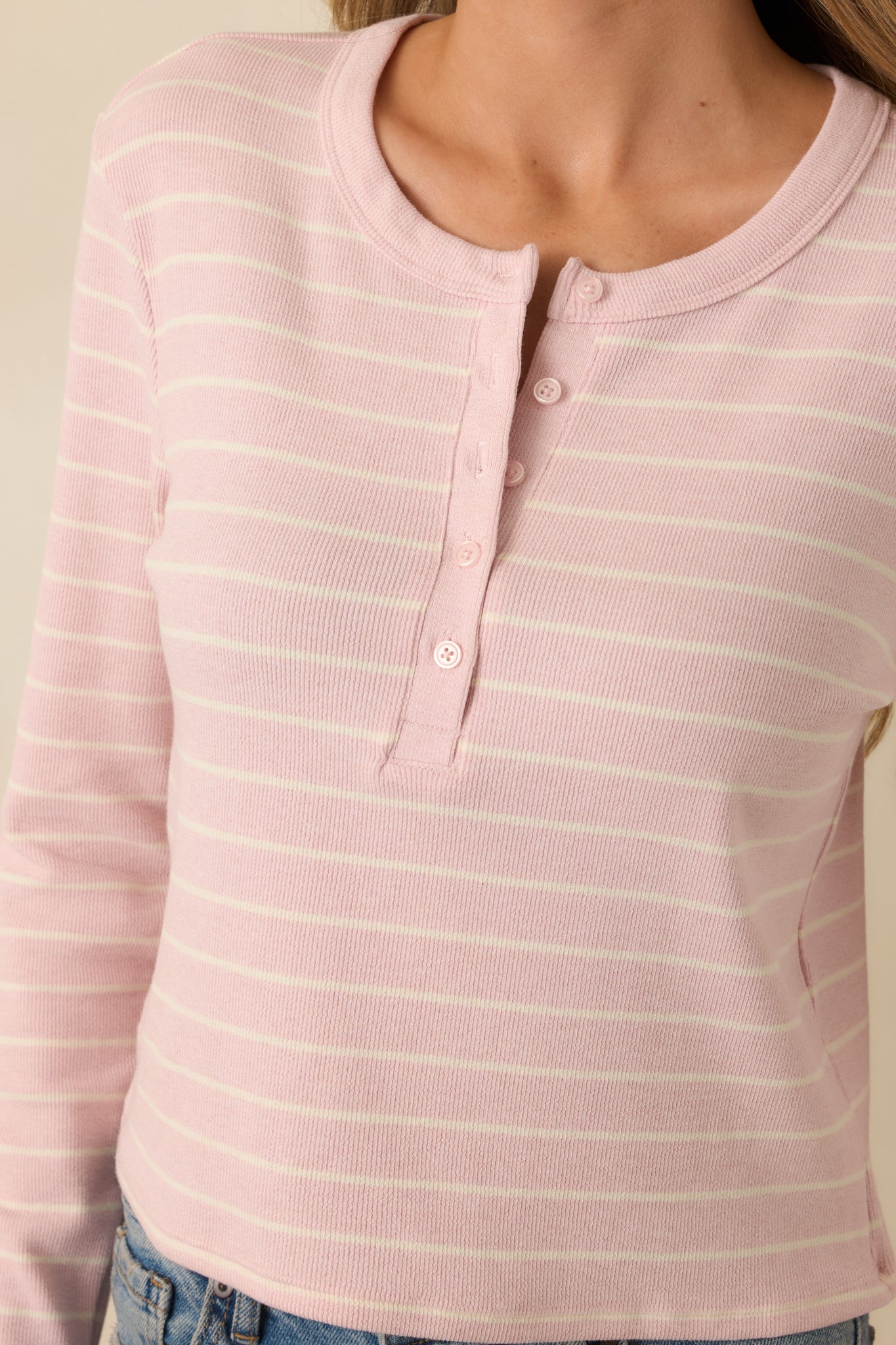 Close-up of the henley placket showing the round neckline, buttons, and fabric texture.