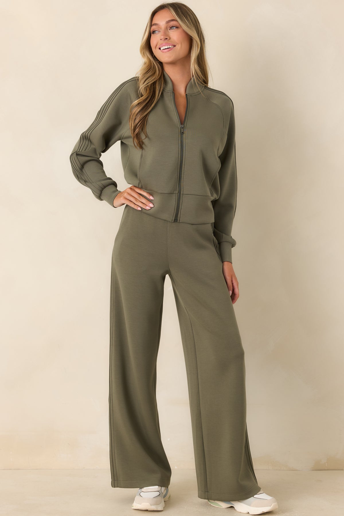 Herb green zip-front jacket featuring raglan sleeves, curved front seaming, stand collar, and a relaxed fit.