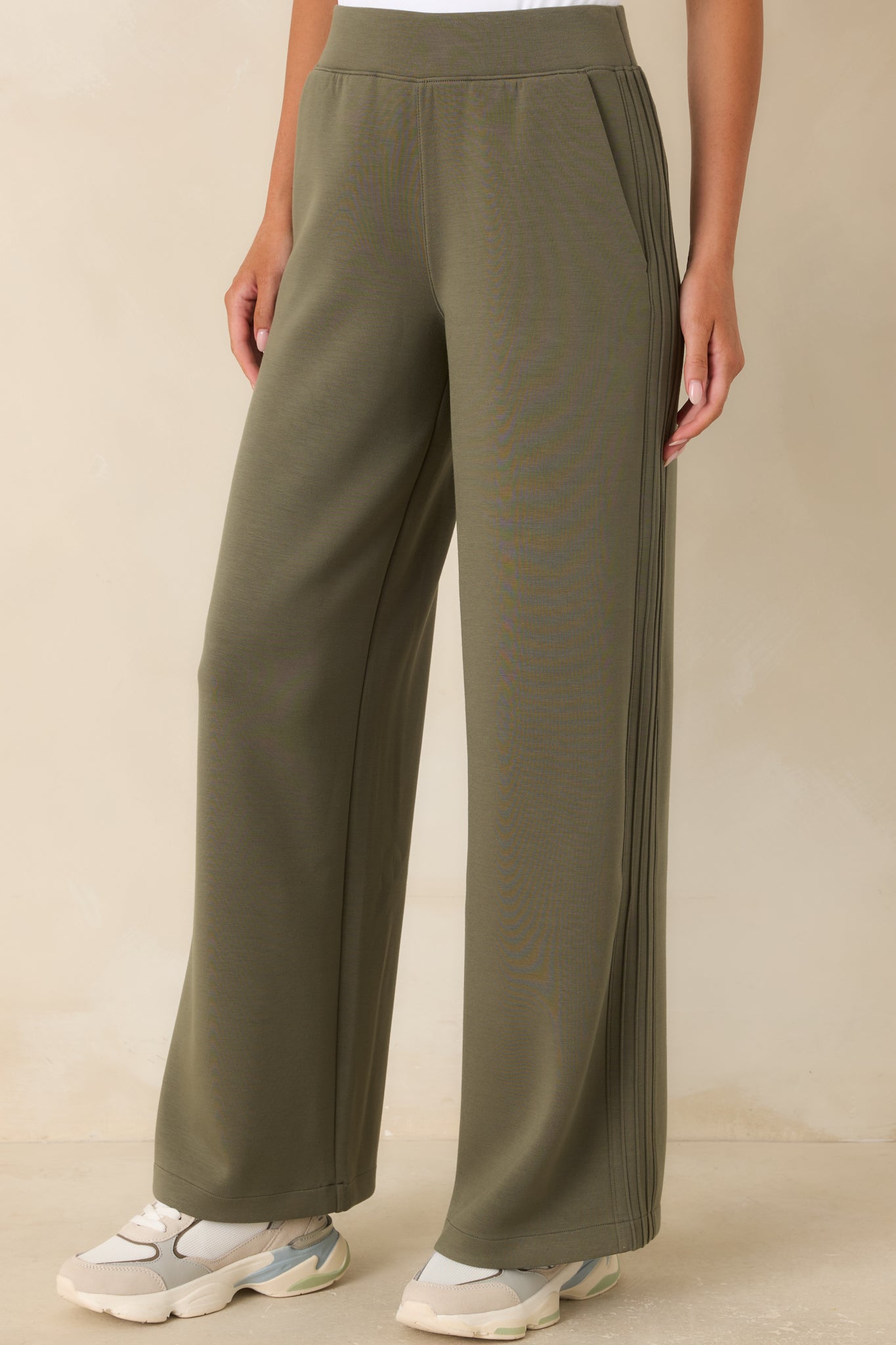 Close view of the herb green pants highlighting the high-rise pull-on waistband, smooth fabric, and clean construction.