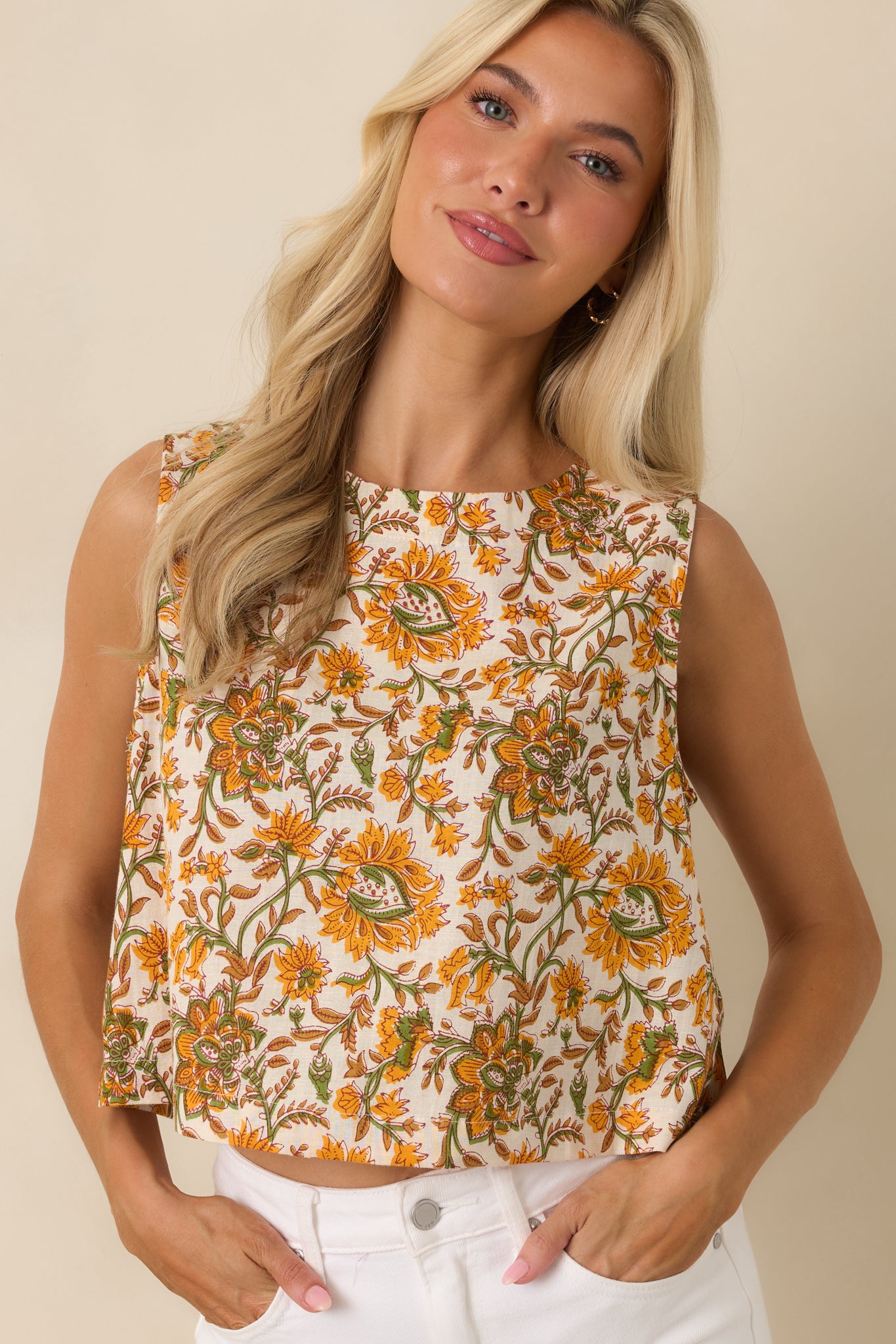 Close view highlighting the high neckline and intricate marigold, olive, and tan floral print on the ivory fabric.
