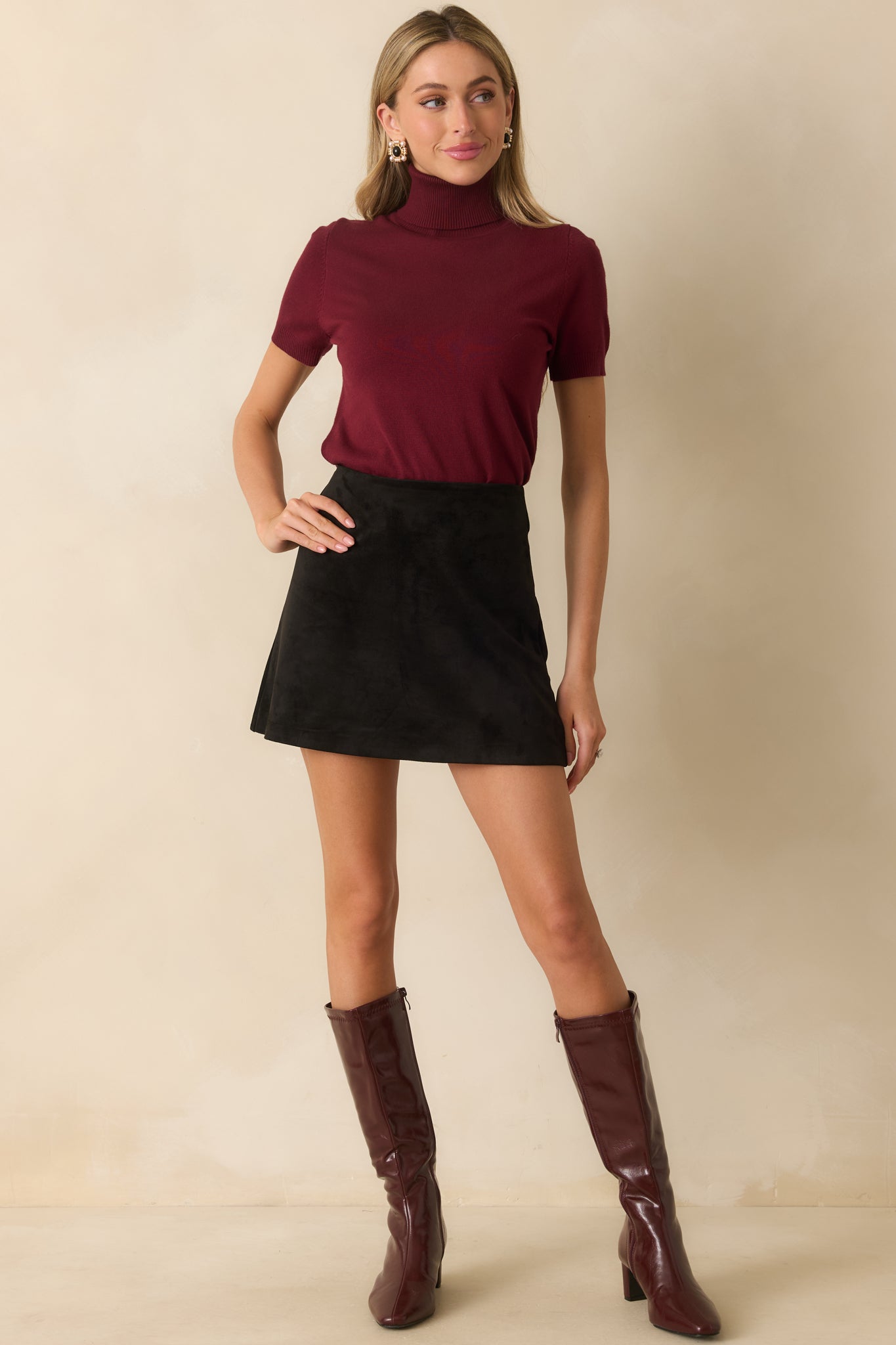 High-rise black faux suede skirt with subtle flare for an A-line shape.