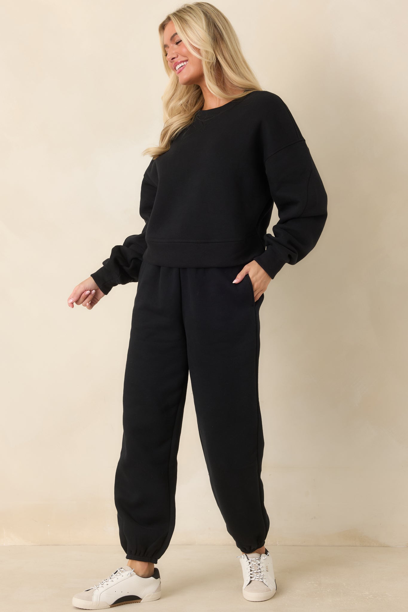 High-rise black jogger pants featuring a comfortable ribbed waistband, elastic ankle cuffs, side pockets, and a smooth finish.