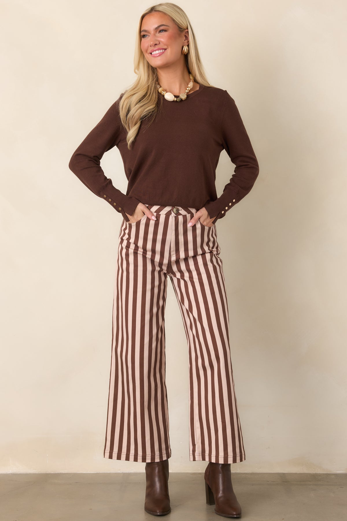 High-rise brown and ivory striped pants featuring a relaxed wide-leg shape, cropped hem, and clean vertical lines throughout.