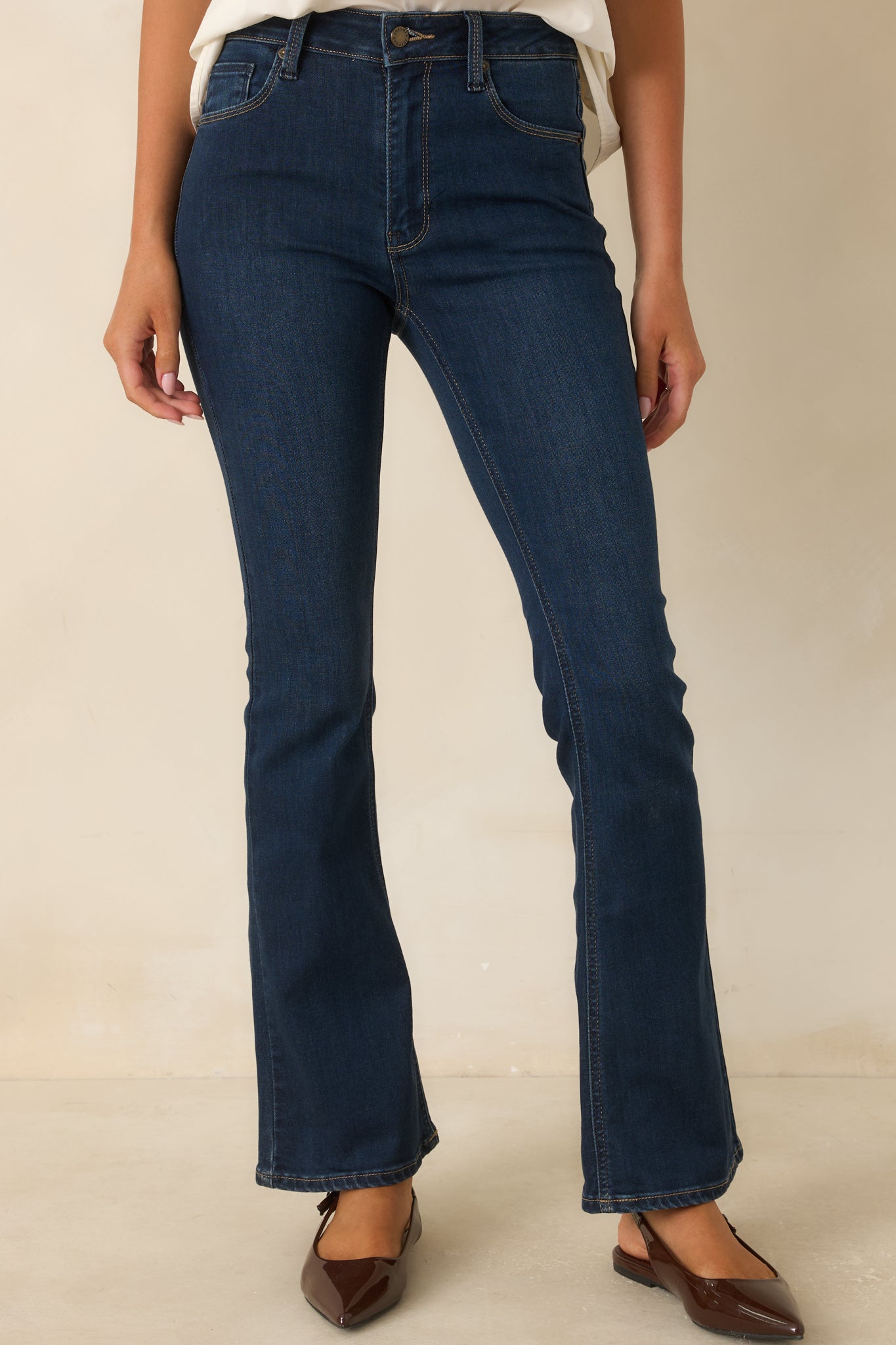 High-rise waistband features a front button and zipper closure for a secure, polished fit.