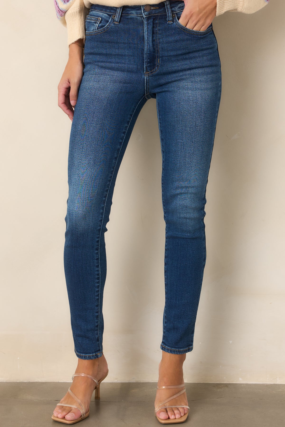 High-rise dark wash jeans showcasing the smooth waistband and sleek front silhouette.