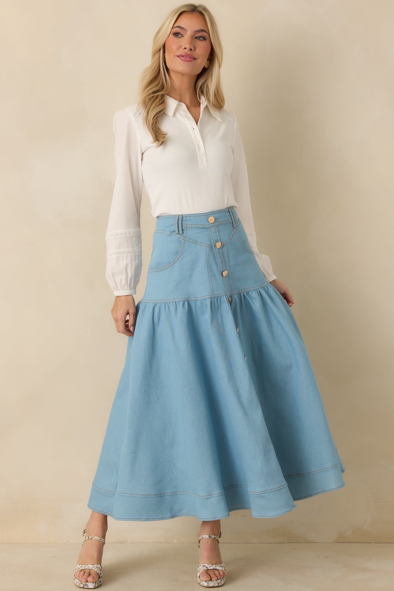 High-rise light wash denim skirt featuring contrast topstitching, front pockets, and a softly flared maxi length.