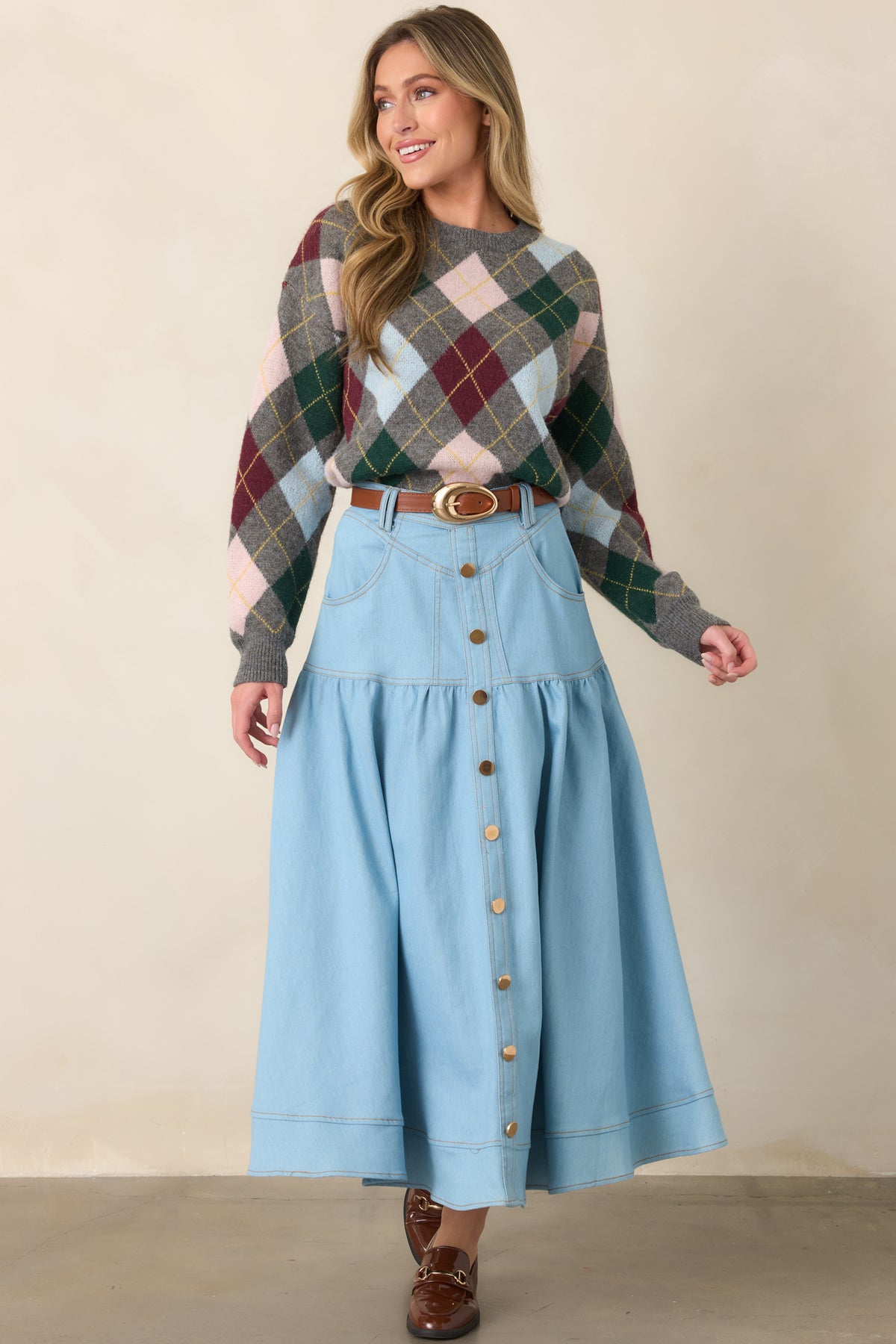 High-rise denim maxi skirt featuring contrast topstitching, front pockets, belt loops, and a flowing tiered shape with a wide hem.