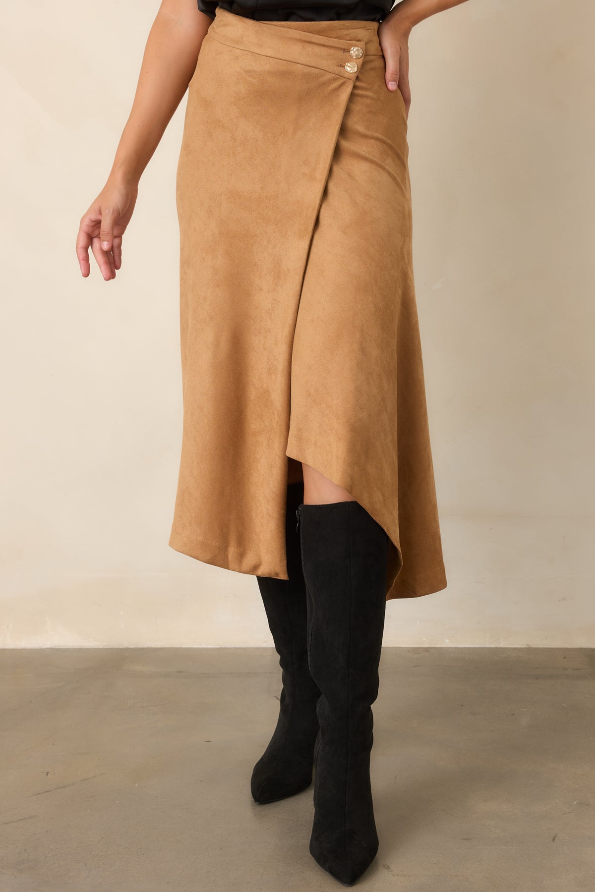 High-rise faux suede skirt highlighting the asymmetrical wrap front and hammered gold-tone buttons.