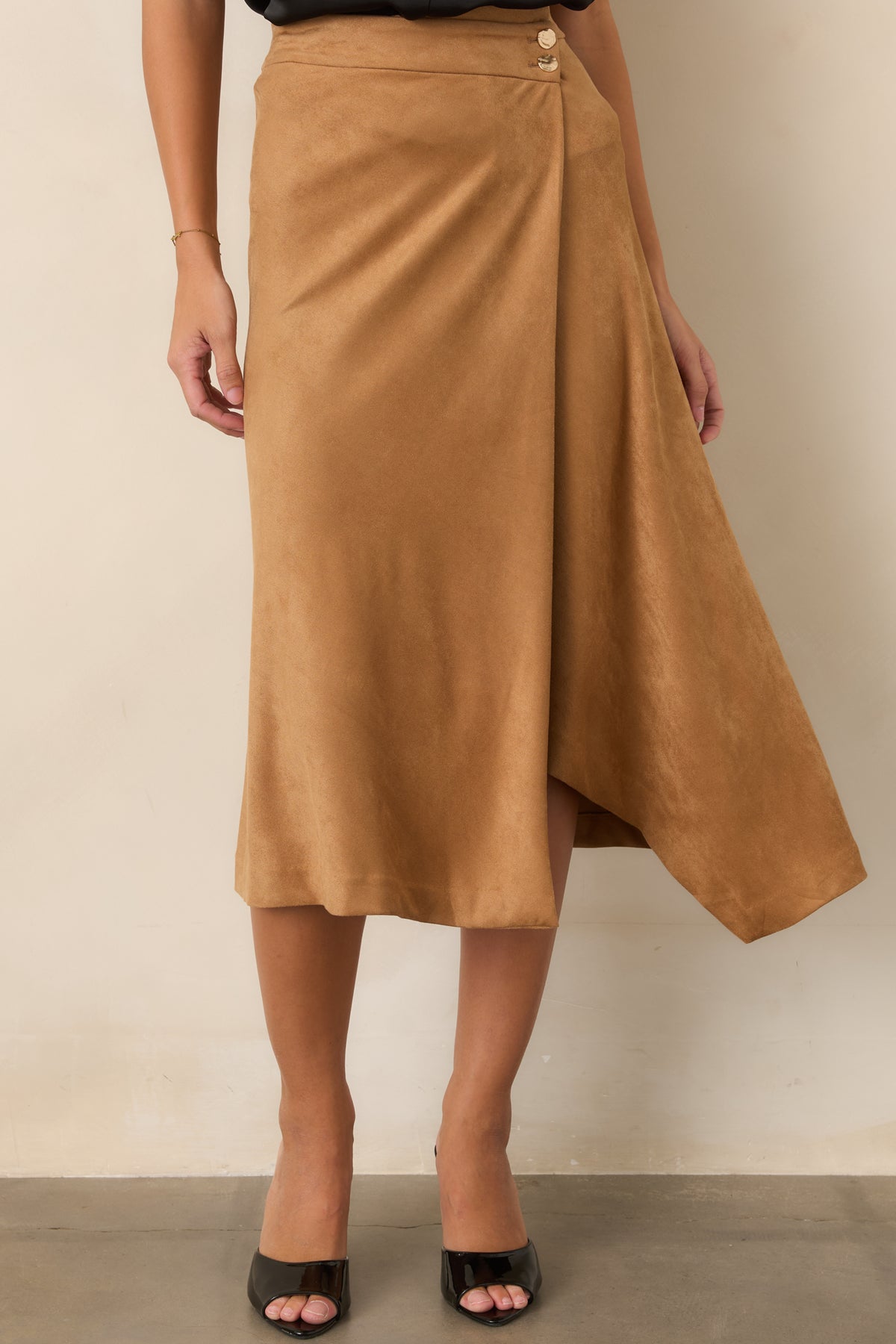 High-rise faux suede skirt showcases an asymmetrical wrap front with two polished hammered gold-tone buttons.