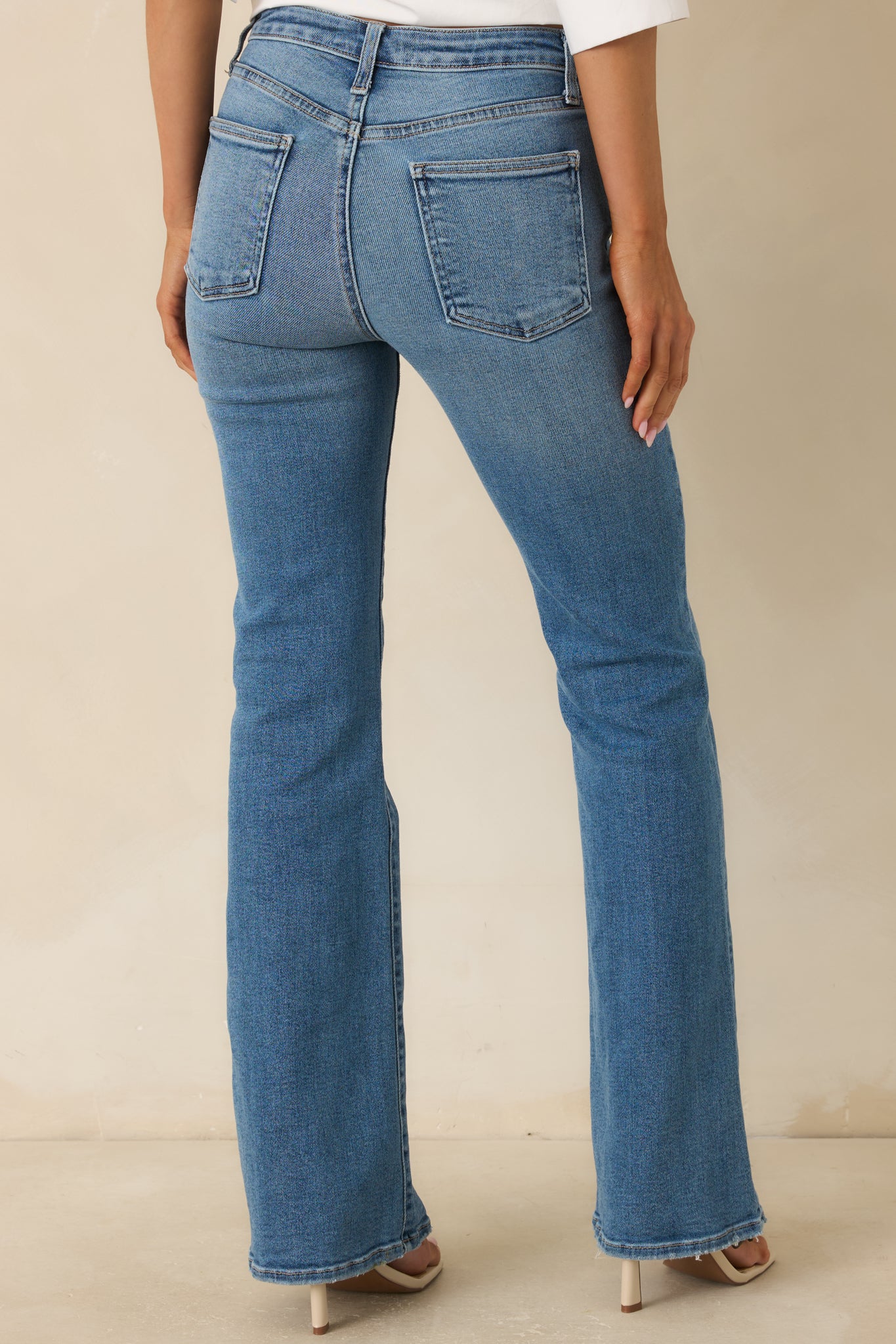 Back view of high-rise flare jeans featuring a relaxed fit, classic denim pockets, and soft flared hems.