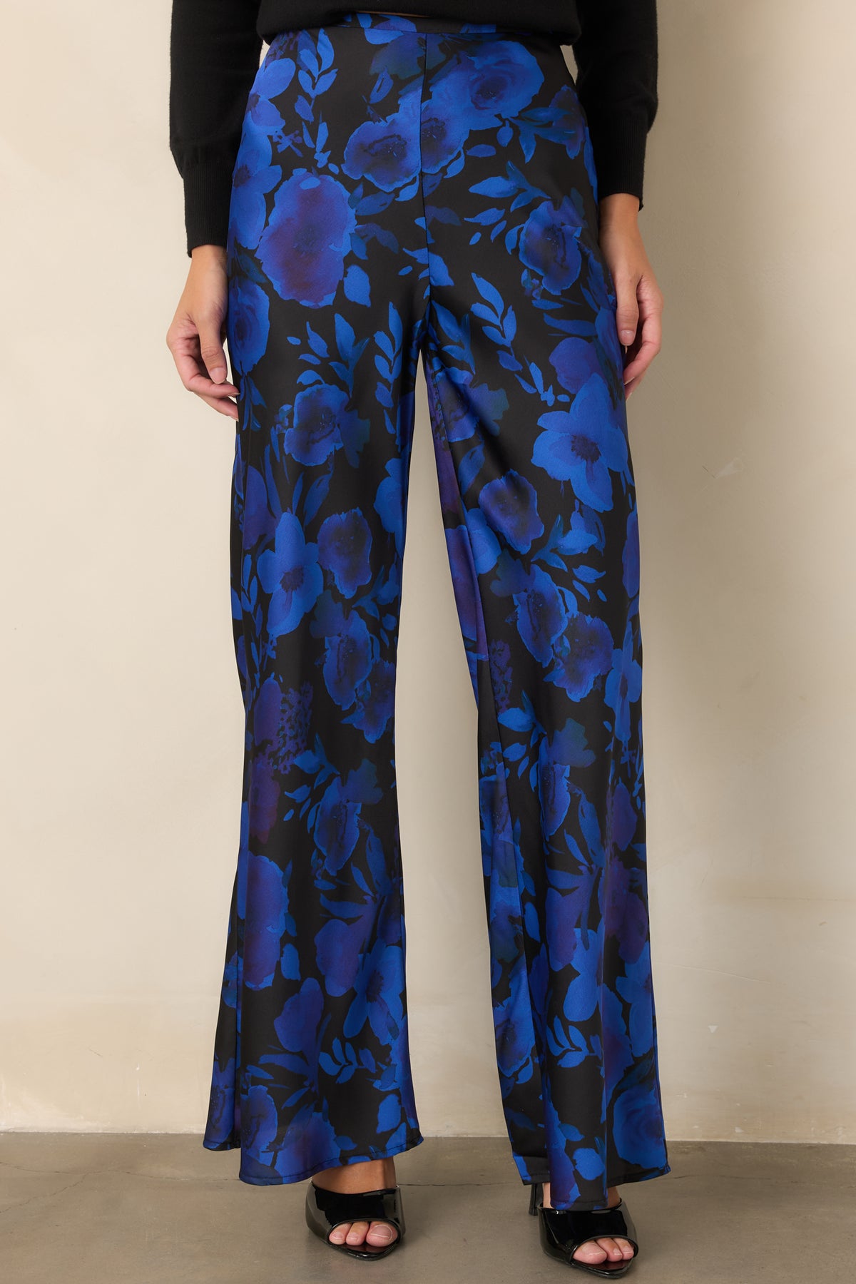High-rise floral satin pants with a smooth waistband and flowing wide-leg silhouette.