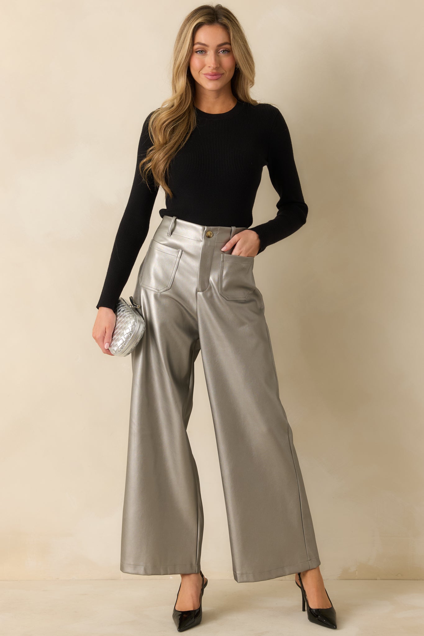 High-rise grey metallic pants catching the light with a sleek shine and effortless wide leg flow.