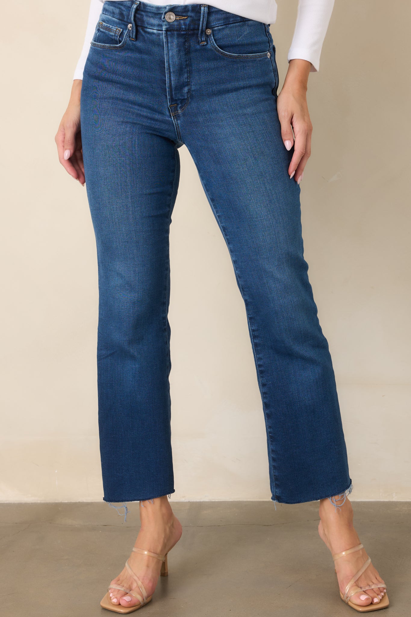 Front detail of the indigo jeans highlighting the high-rise waistband and slim fit through the hips and thighs.