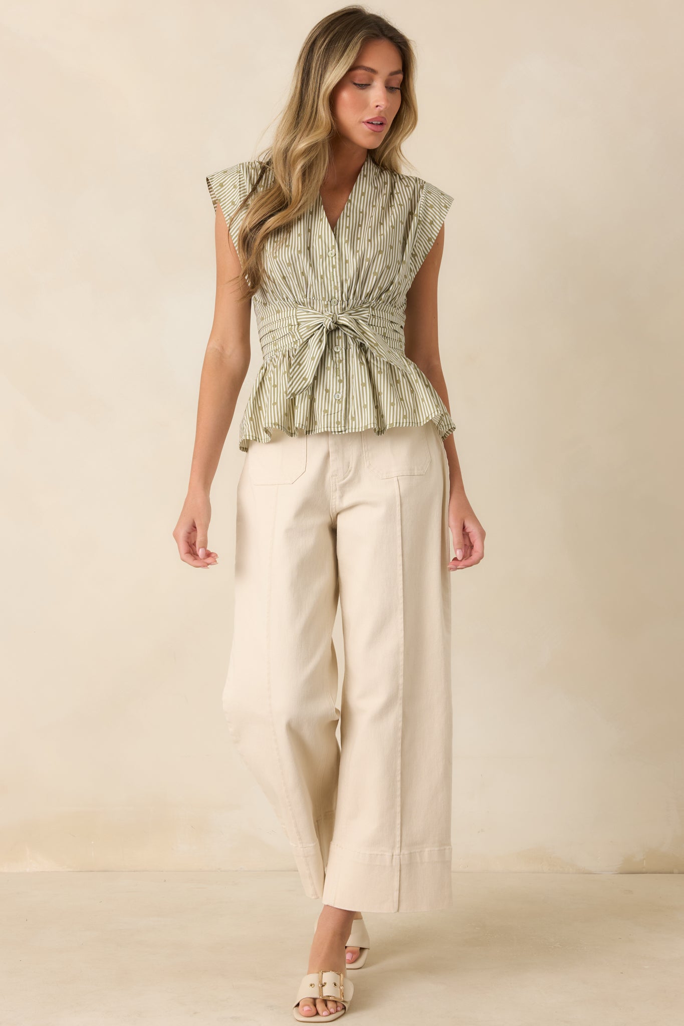 High-rise ivory trousers showcasing oversized front pockets, clean tailoring, and a versatile wide-leg cropped shape.