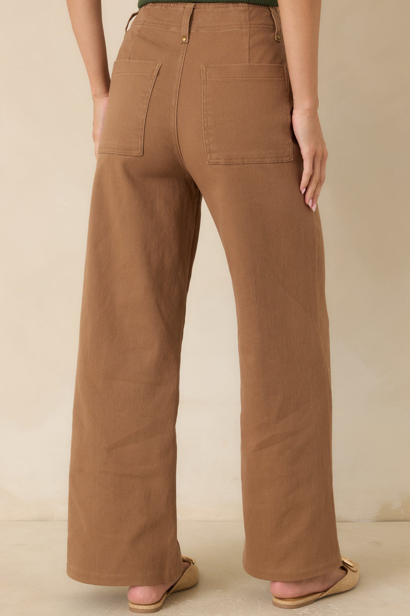 Rear view of the high-rise pants featuring oversized back patch pockets and a relaxed tailored fit.