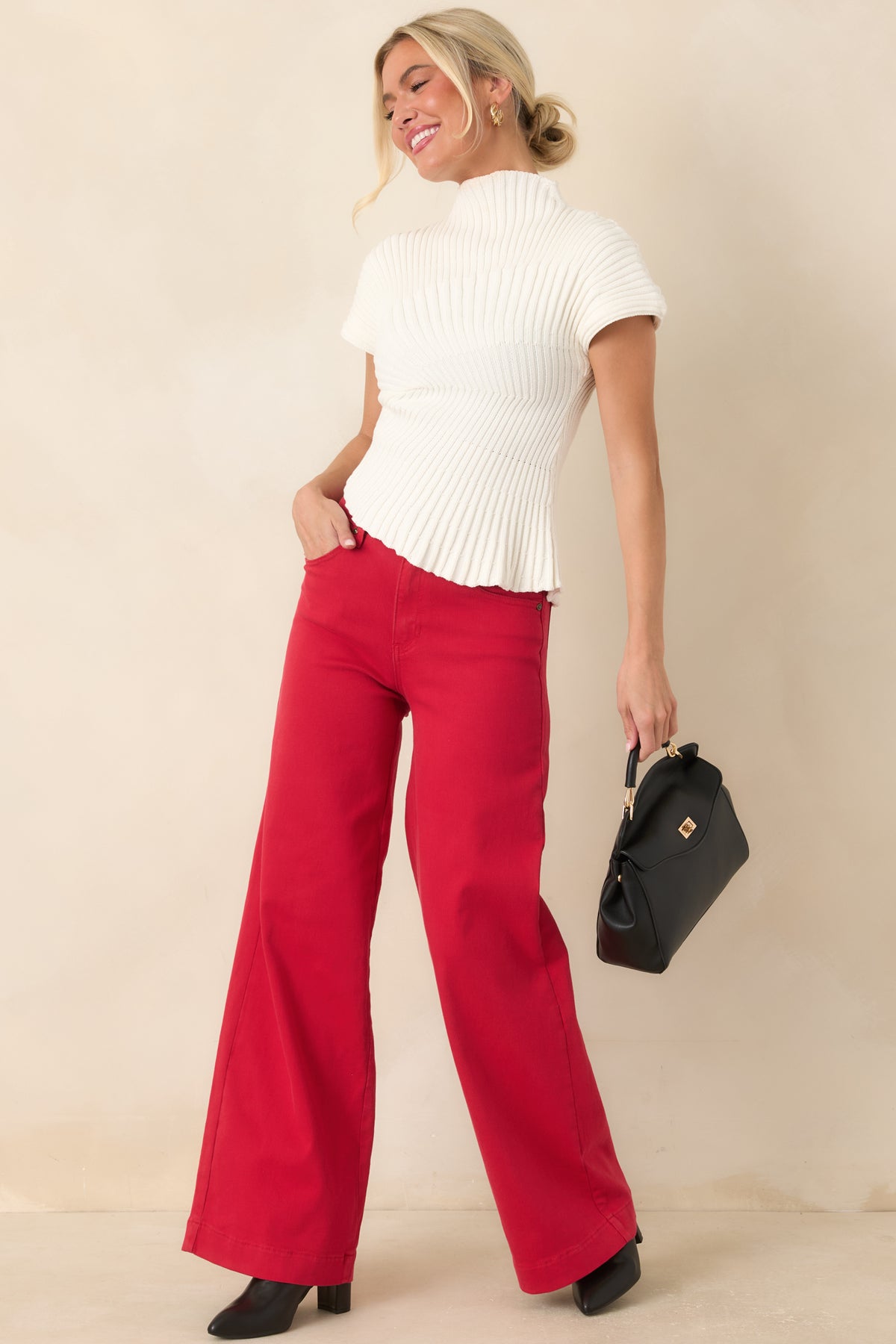 High-rise red jeans showcasing a fitted waist, classic five-pocket styling, wide legs, and clean full-length design.