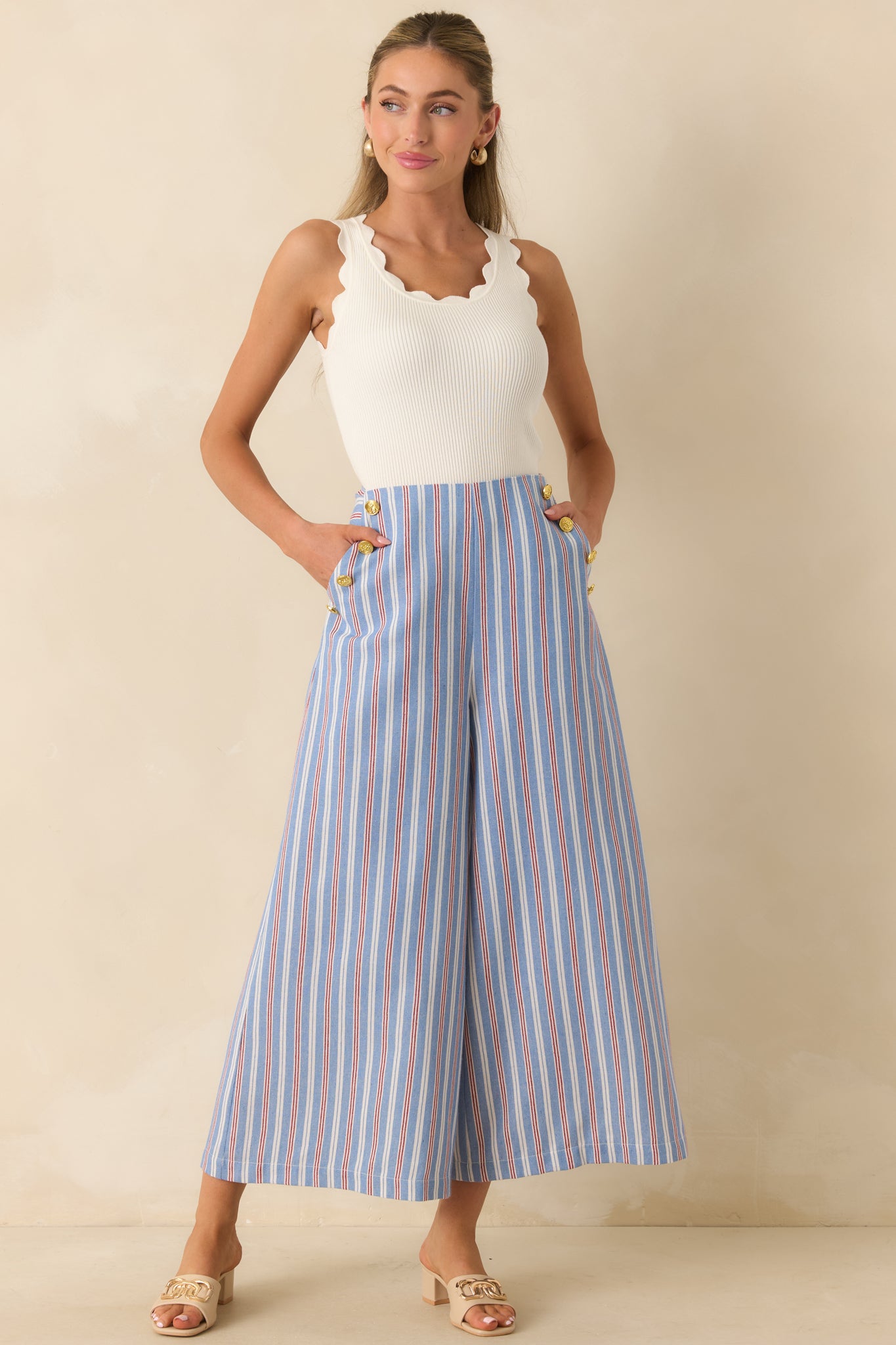 High-rise striped pants showcasing a tailored waist, gold-tone sailor-inspired button details, and an easy-flowing wide leg design.