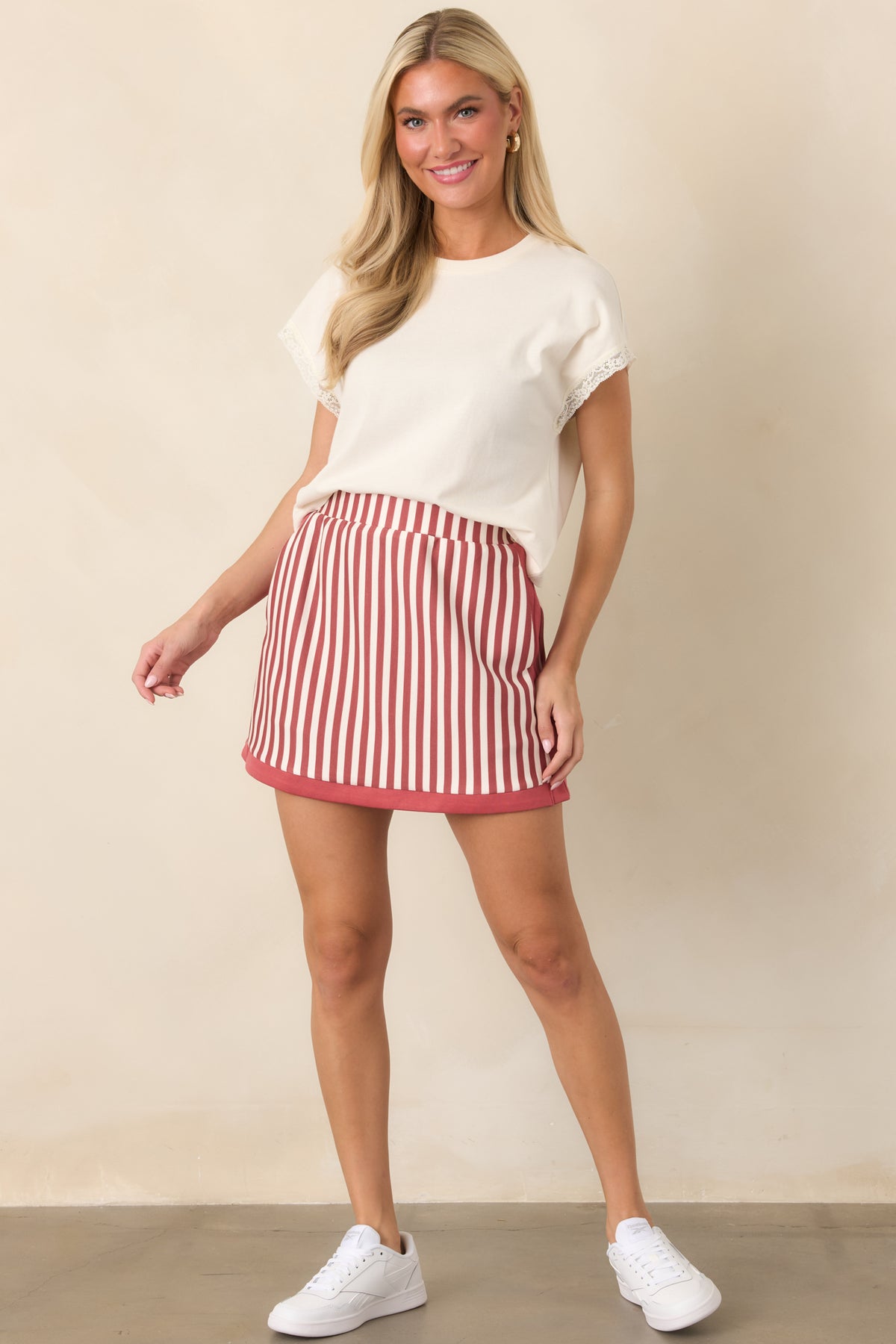 High-rise striped skort featuring alternating terracotta and ivory vertical lines, convenient side pockets, and an integrated short lining.