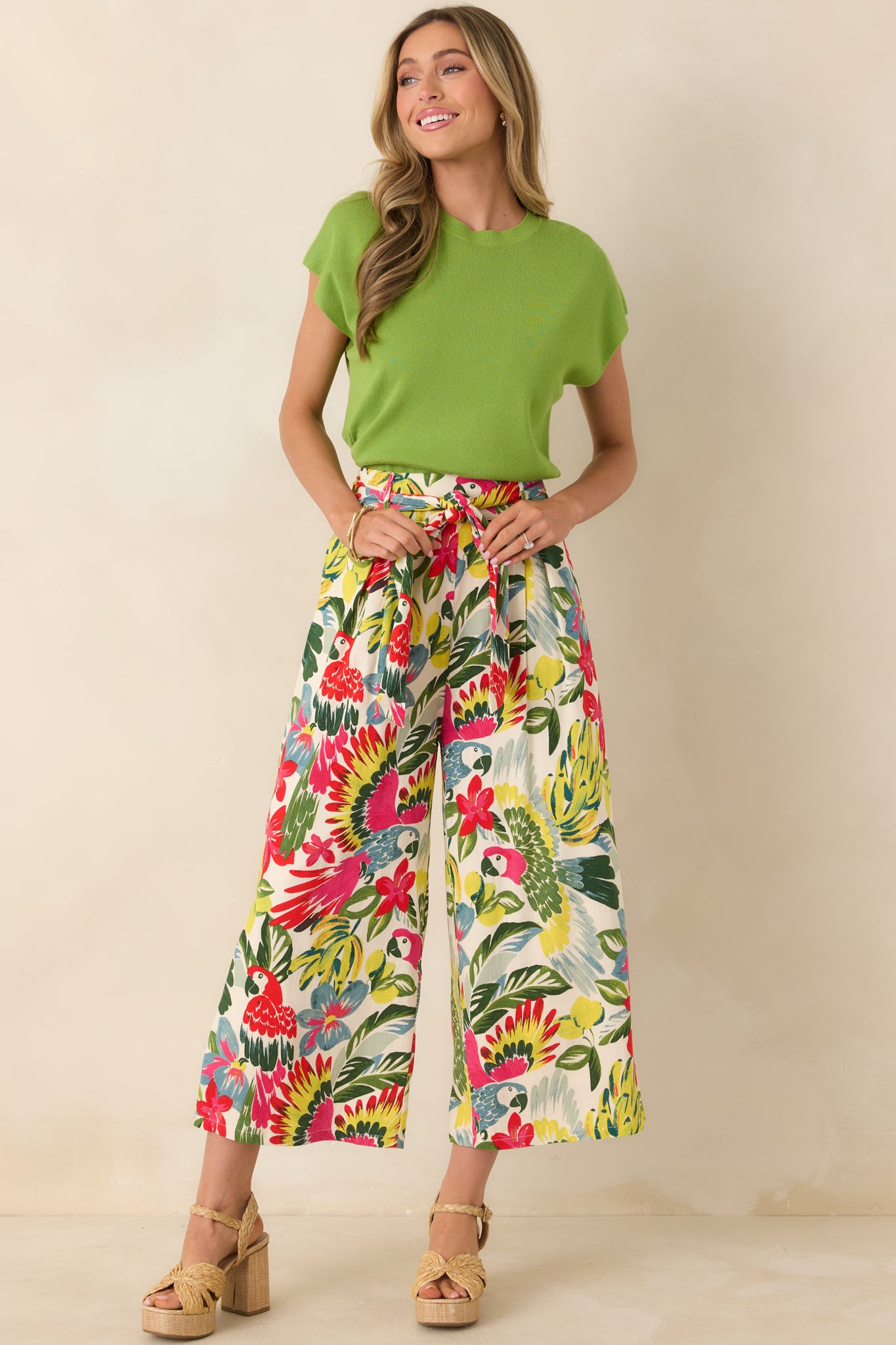 High-rise tropical print pants with vibrant parrots and florals, cropped wide-leg silhouette, and self-tie waist belt