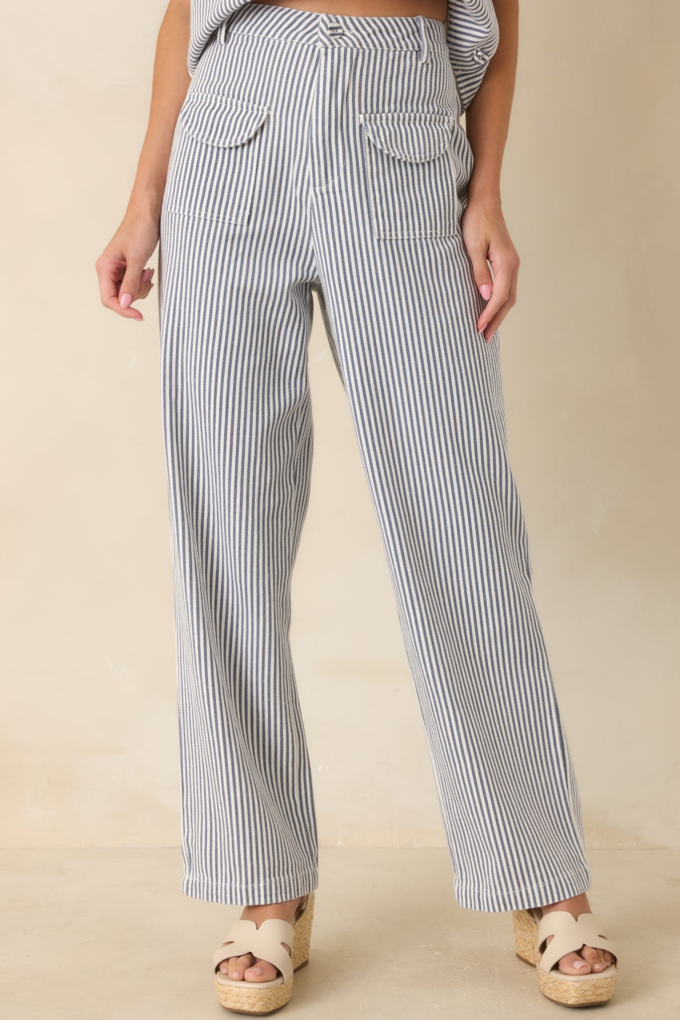 Detailed view of the high-rise waistband, belt loops, and blue and ivory stripe pattern.
