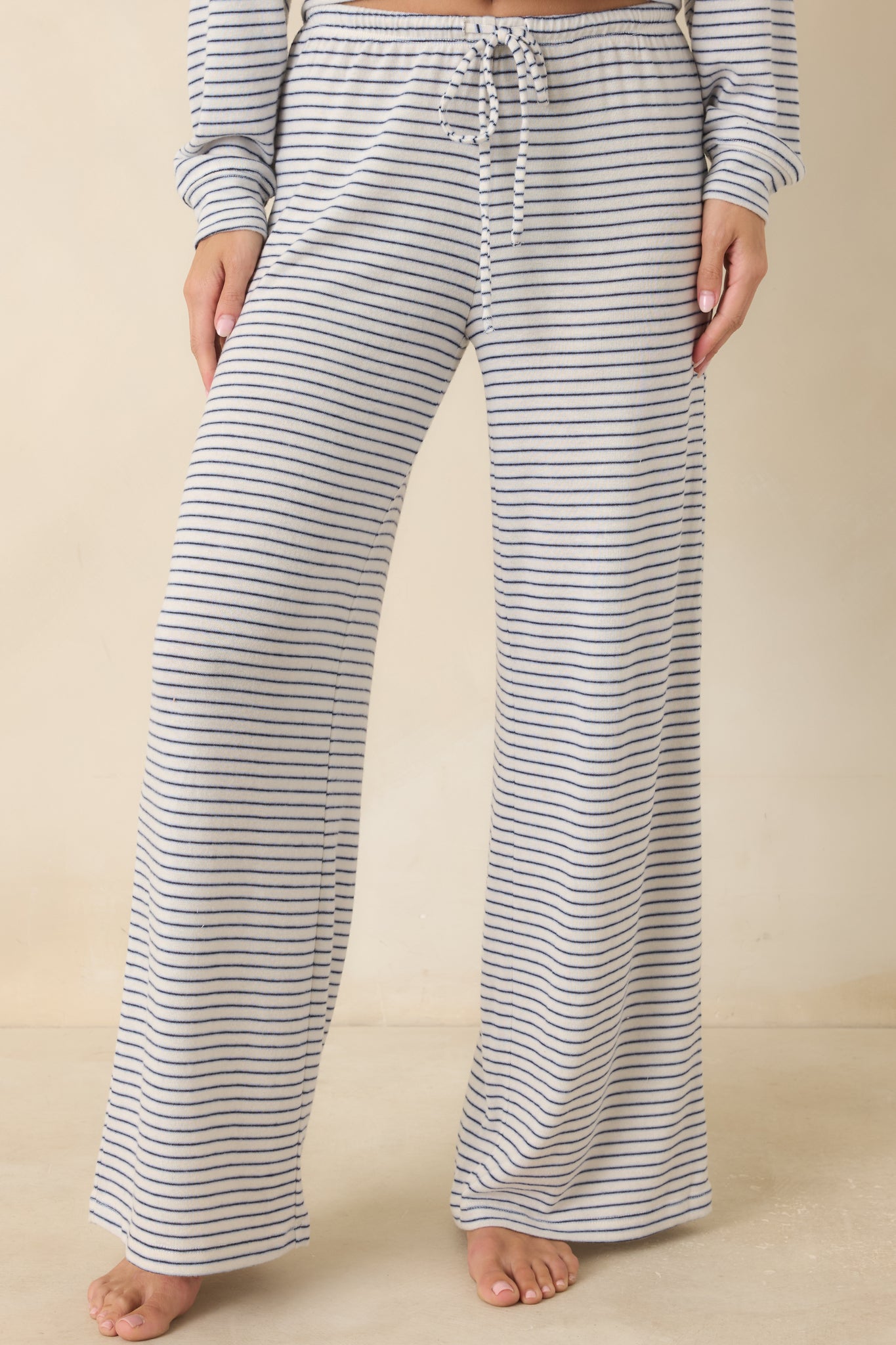 Detailed view of the high-rise elastic waistband with adjustable drawstring on navy striped pants.
