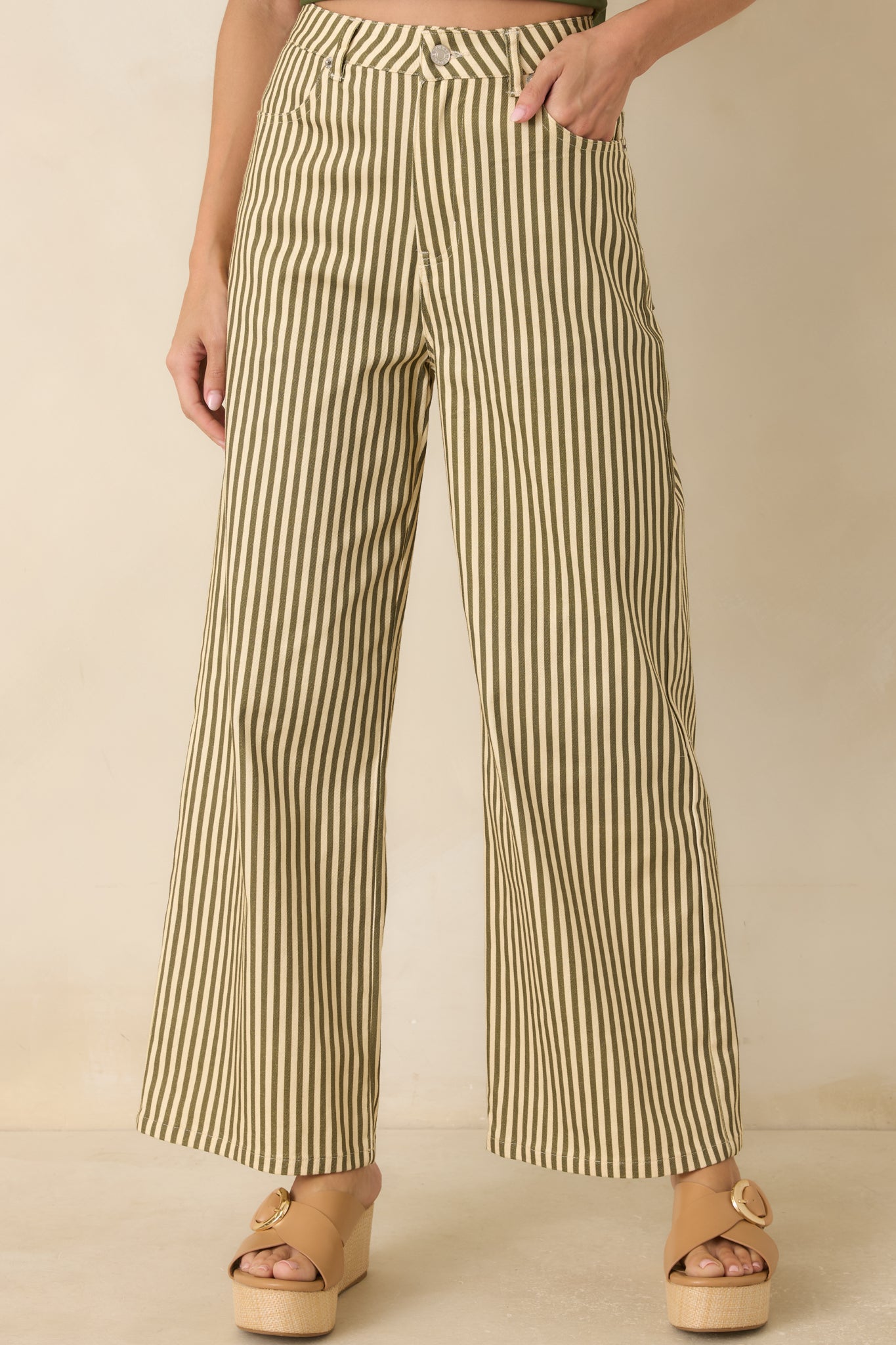 Close view of the high-rise waistband featuring belt loops, button closure, and vertical stripe detailing.