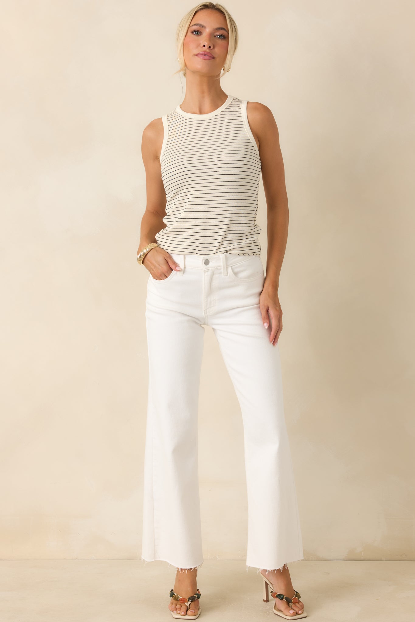 High-rise white denim jeans showcasing a classic button and zipper closure with a relaxed straight-leg silhouette.