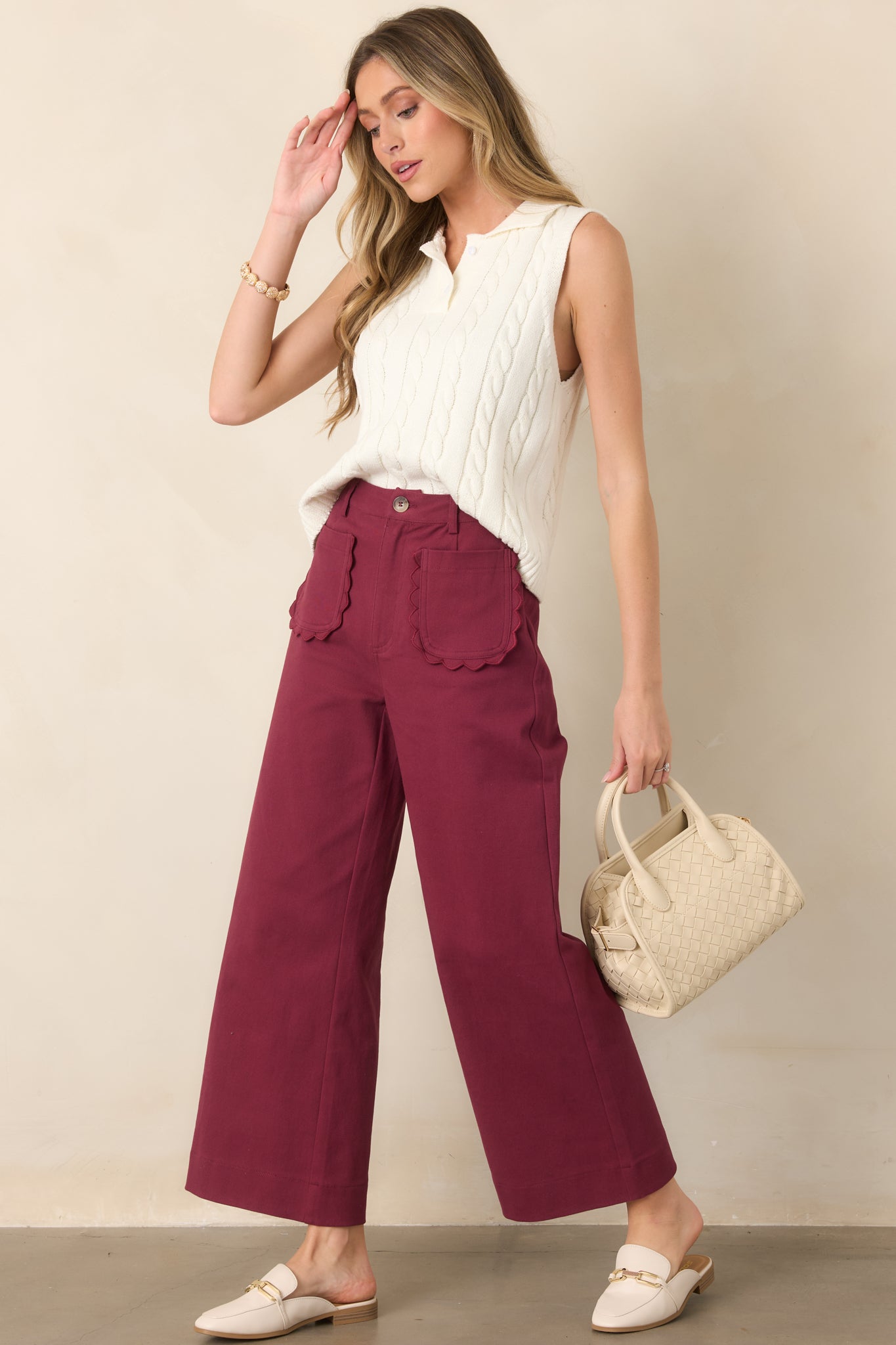 High-rise wide-leg pants with a front button and zipper closure, belt loops, scalloped front patch pockets, and structured woven cotton fabric.