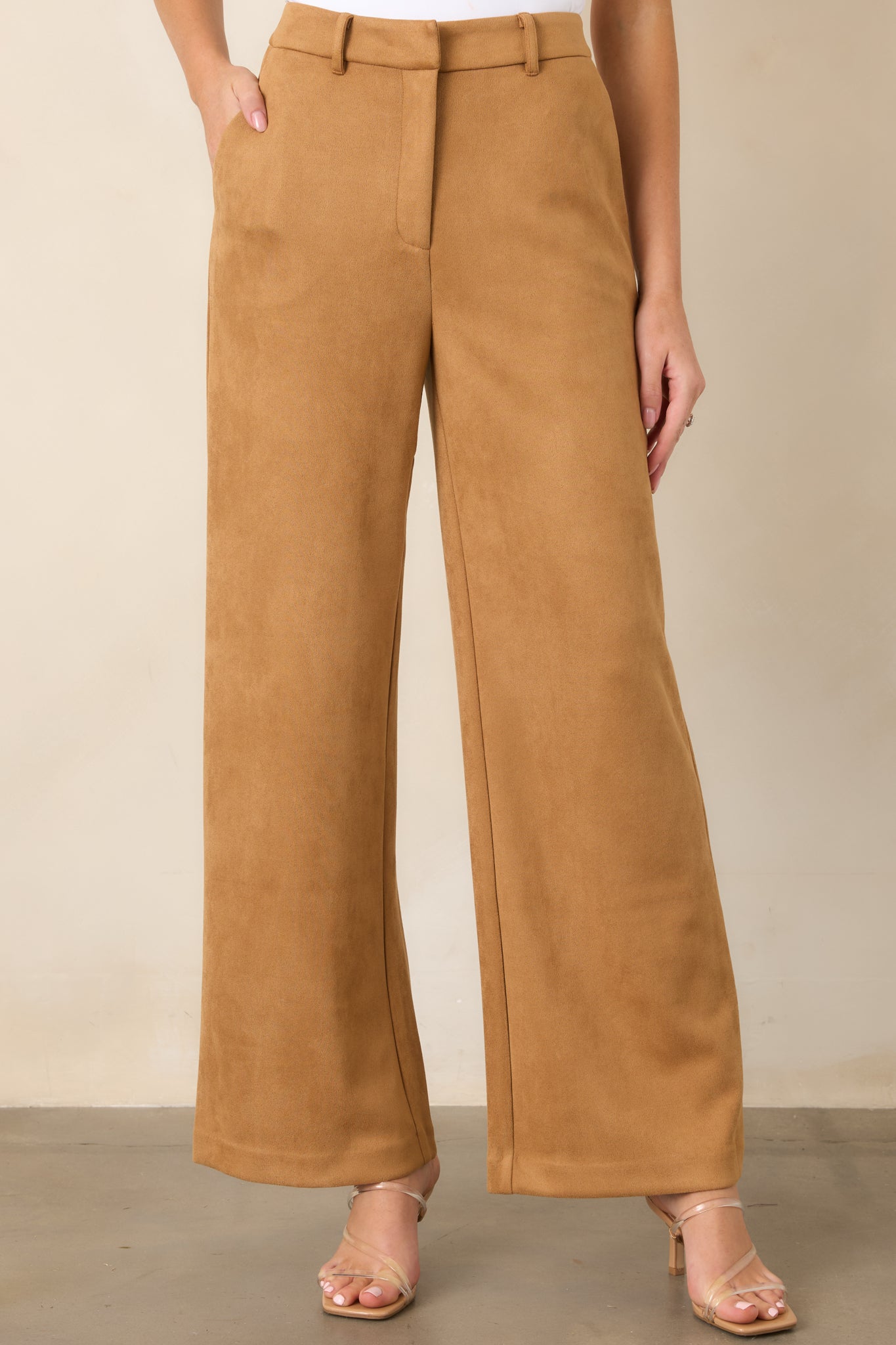 Front detail of the wide-leg pants highlighting the structured high-rise waistband, belt loops, and concealed front closure.
