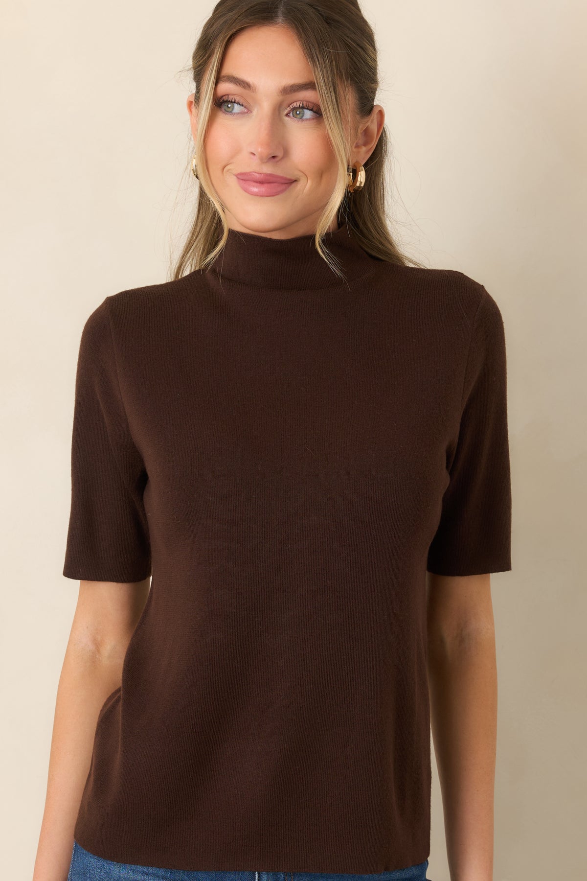 High turtleneck knit top featuring short sleeves and a smooth, streamlined silhouette.