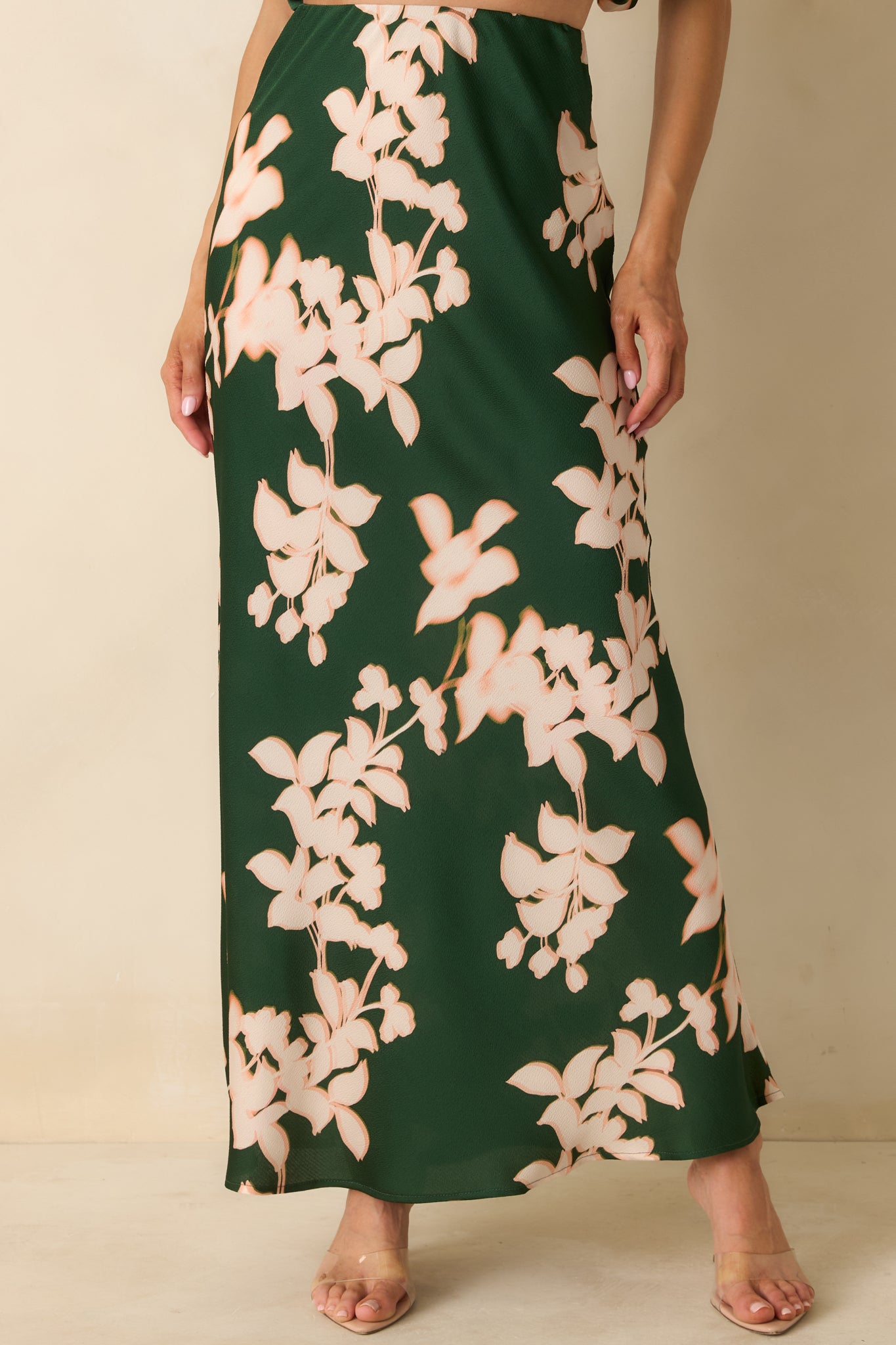 The high waist and upper section emphasize the hammered satin texture and green floral pattern.