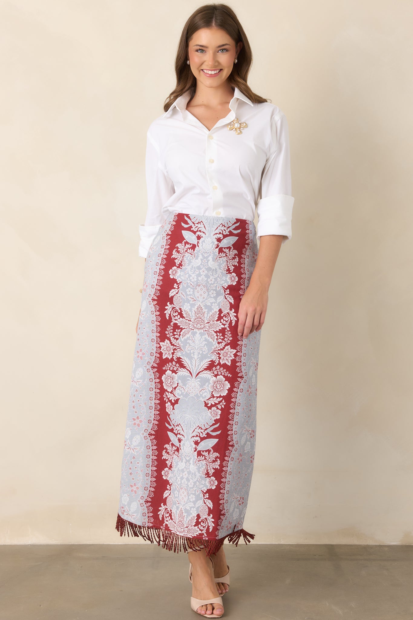 Polished high-waisted skirt with a long column silhouette and textured fringe hem for a subtle statement finish.