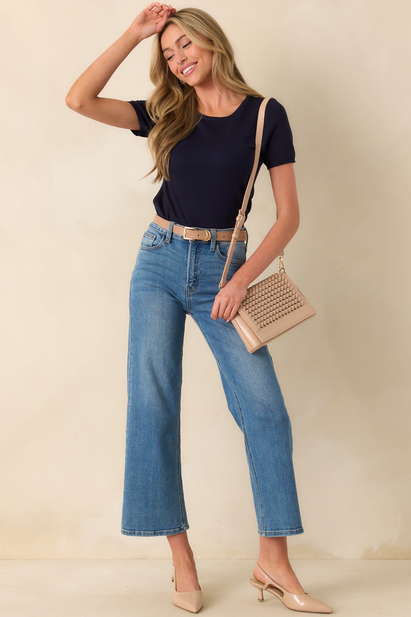 High-waisted cropped jeans featuring a classic button and zipper closure, belt loops, and functional front and back pockets.