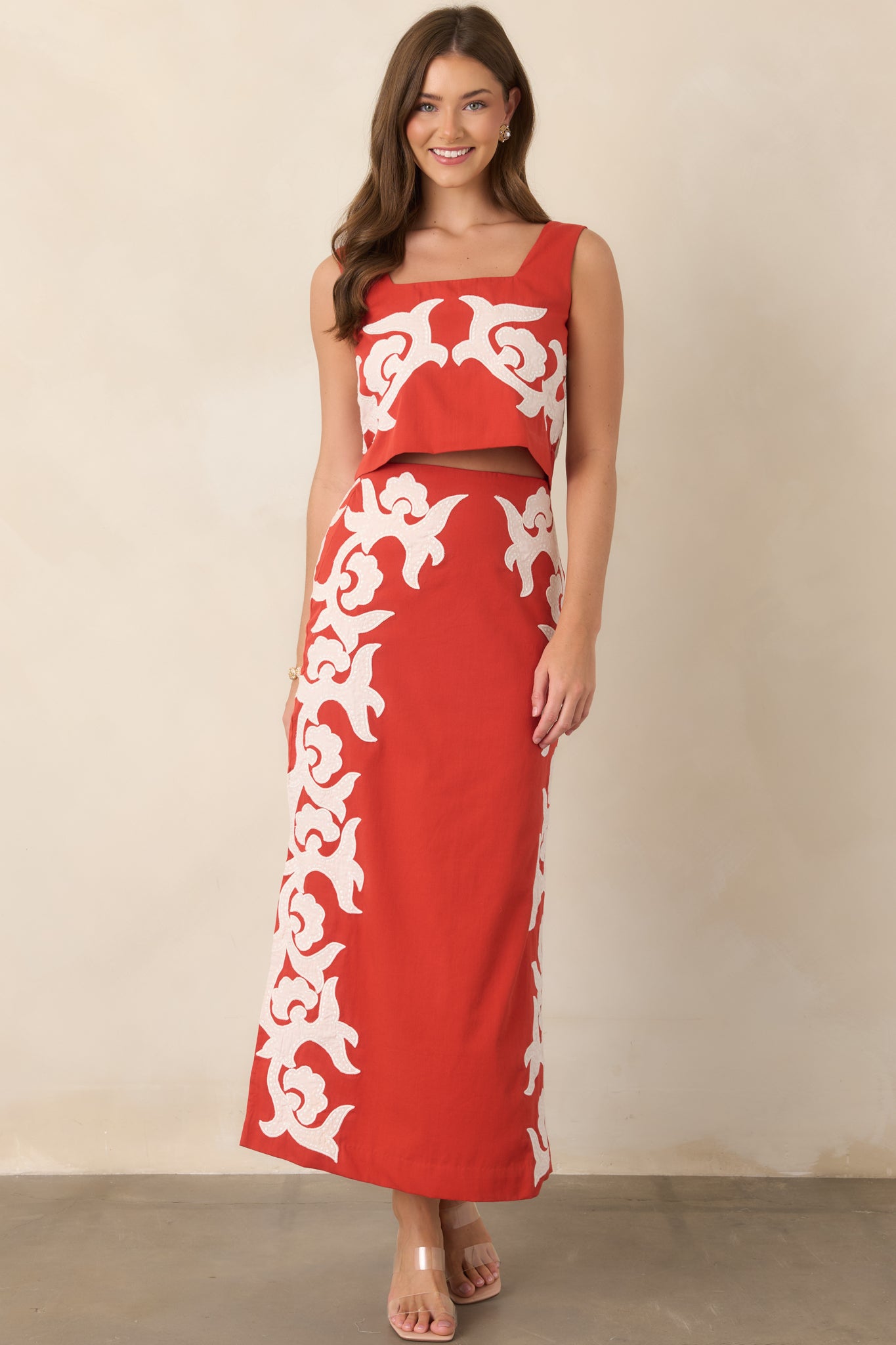 High-waisted cotton midi skirt with bold ivory appliqué detailing, a sleek column silhouette, and side slits for movement.