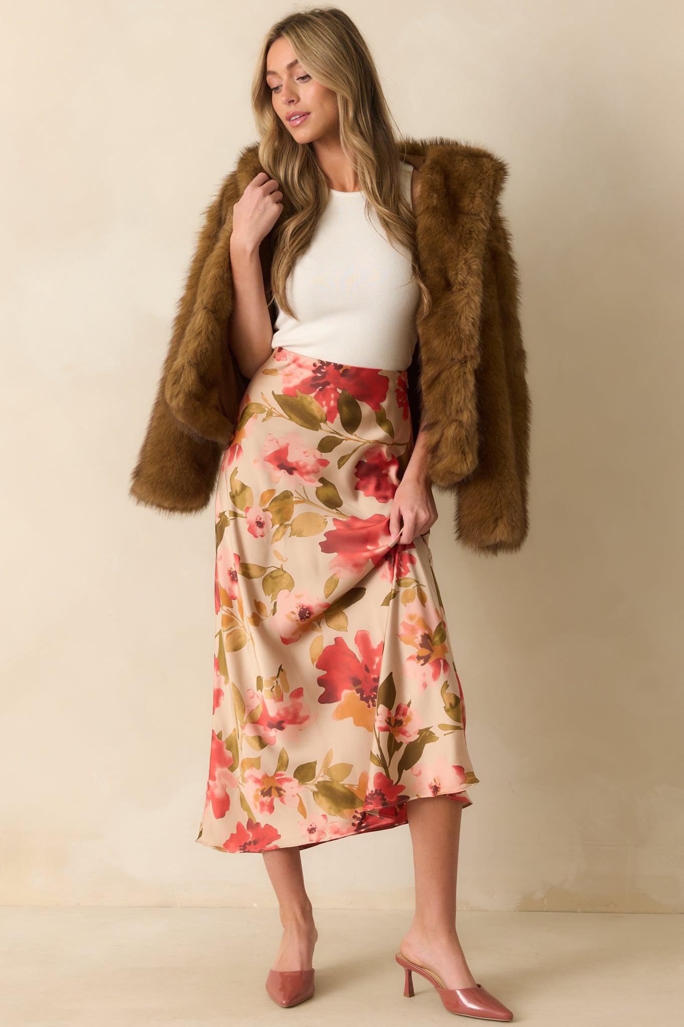 High-waisted tan maxi skirt with subtle pleats and full-length floral print creating a breezy look.