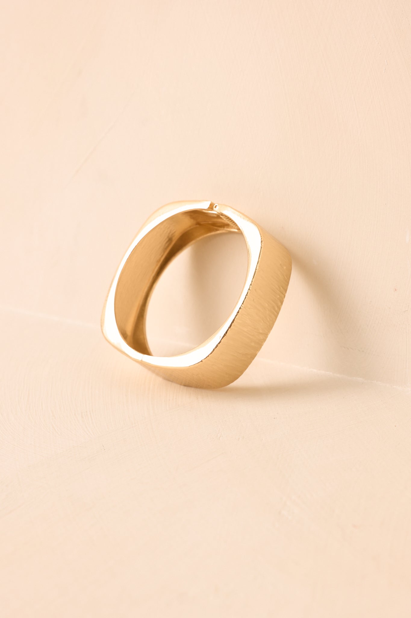 Alternate angle of the cuff bracelet featuring the polished metal finish, brushed detailing, and sleek hinged closure construction.