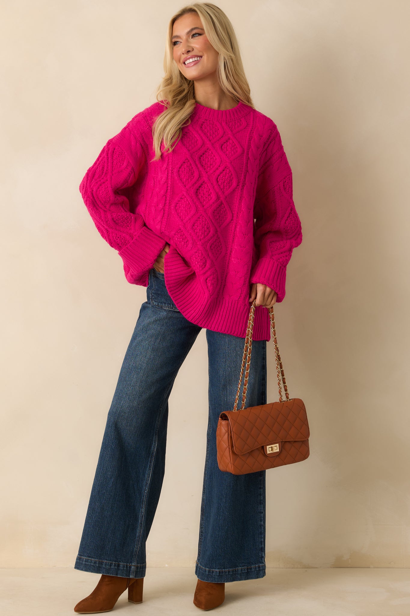 Hot pink cable knit sweater with a crew neckline and relaxed, oversized fit.