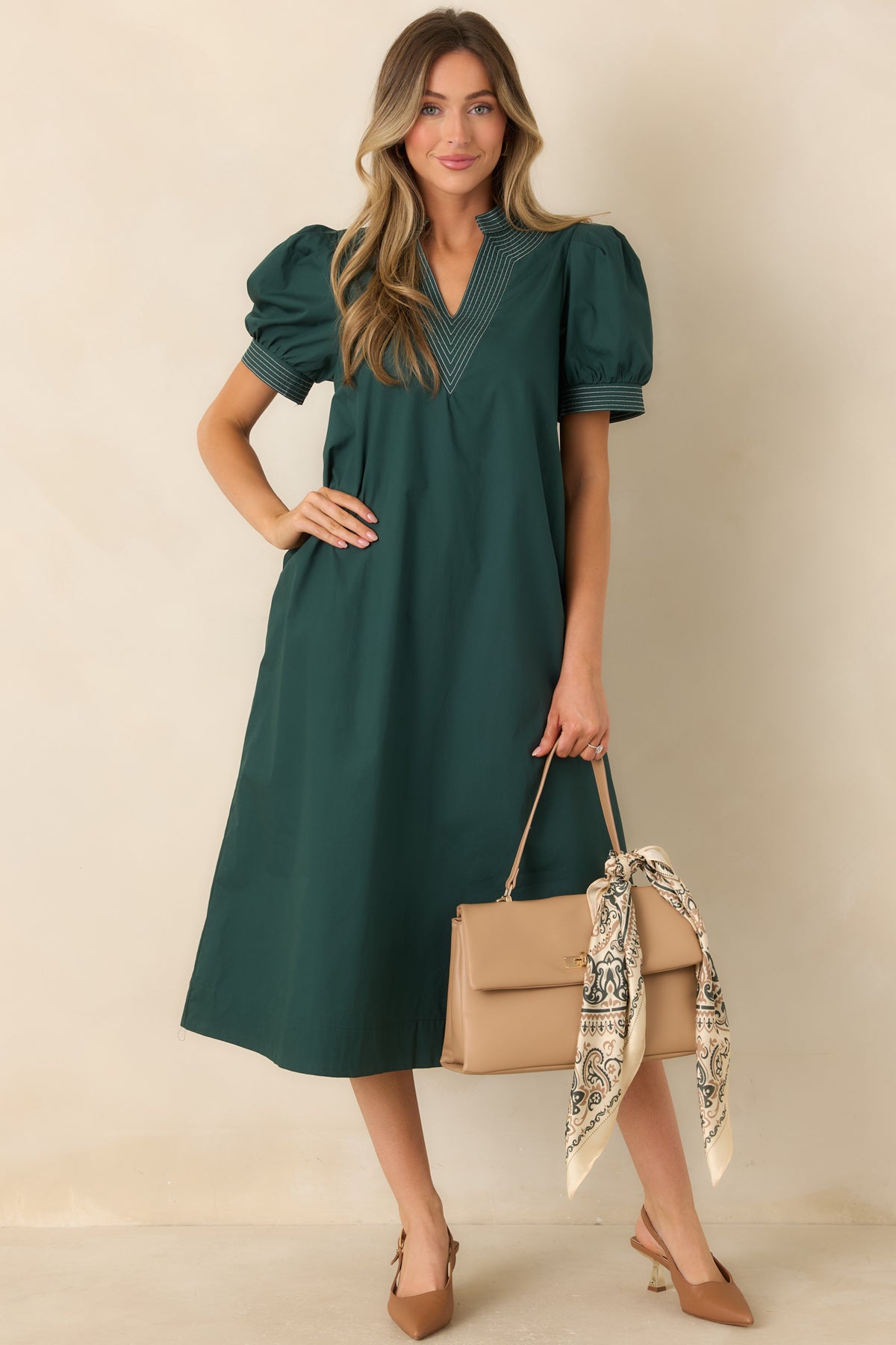 Hunter green A-line dress featuring a structured split neckline, stitched sleeve cuffs, and a midi-length hem.