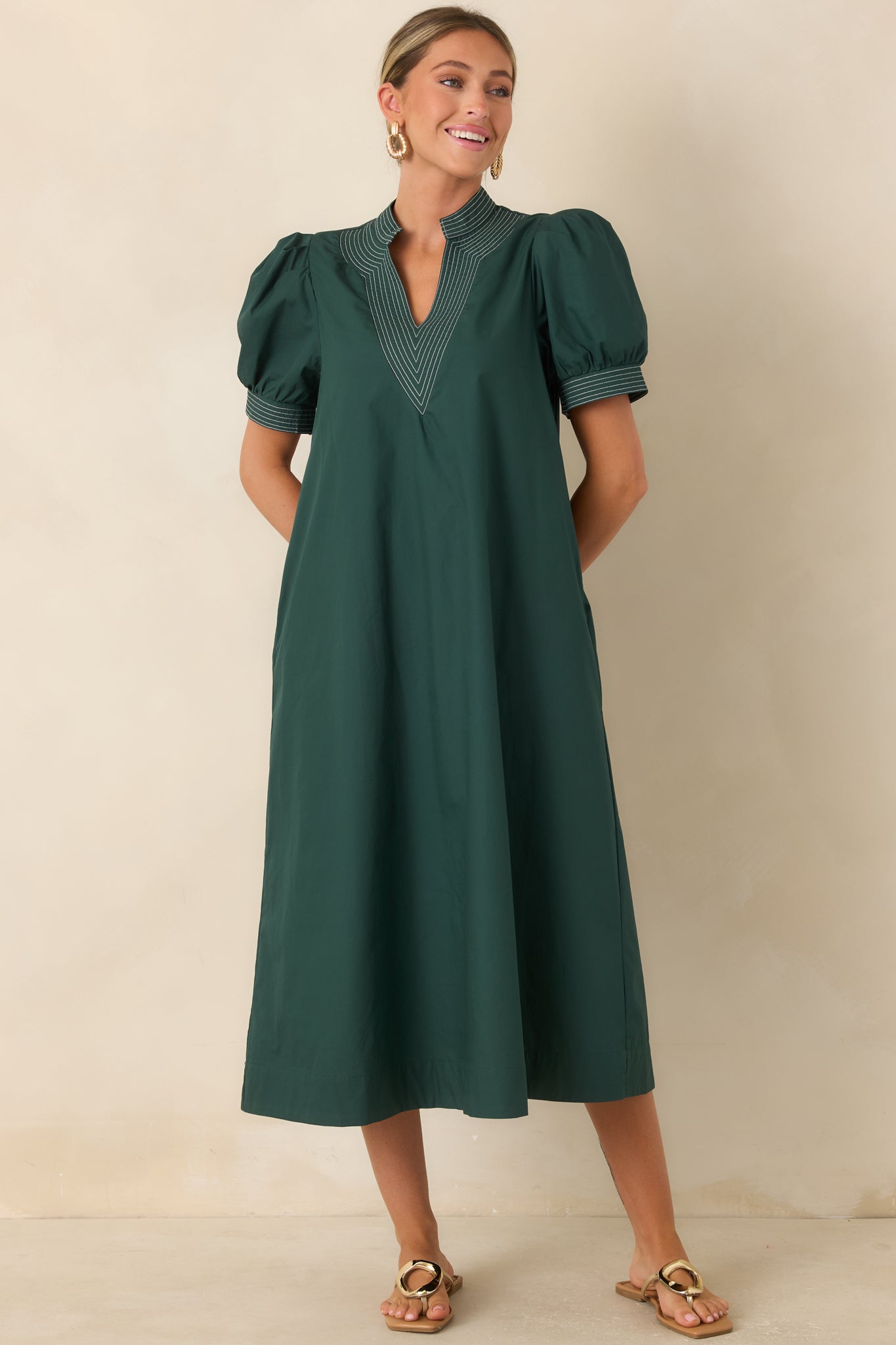 Hunter green dress showcasing layered contrast stitching, puff sleeves, and a fully lined construction.